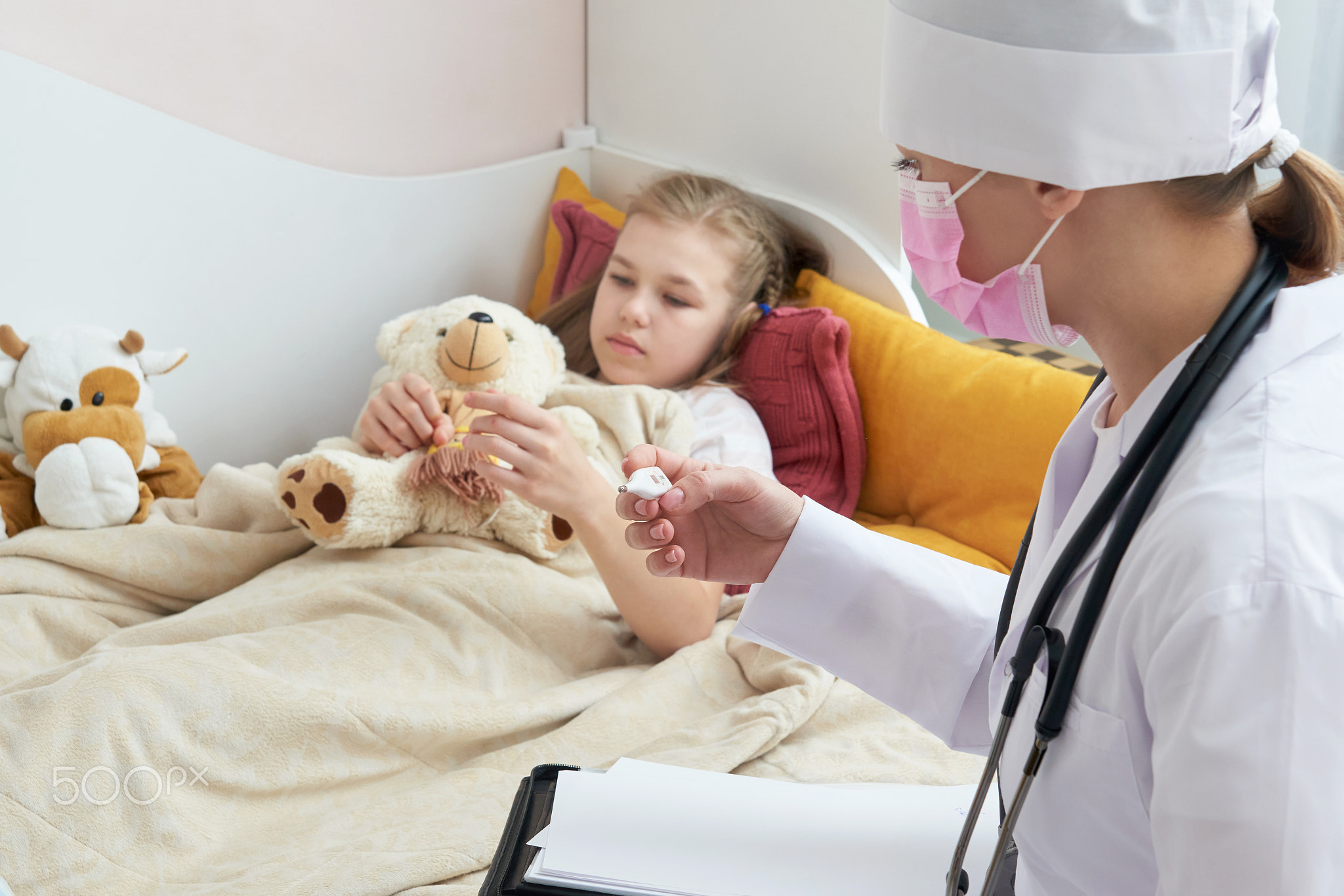 Doctor holding thermometer and checking ill little girl.Sick little