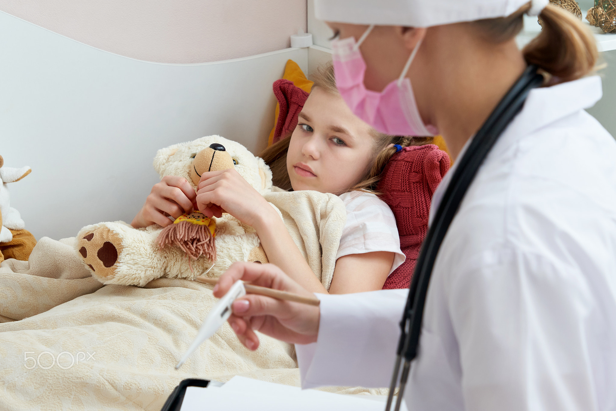 Doctor holding thermometer and checking ill little girl.Sick little