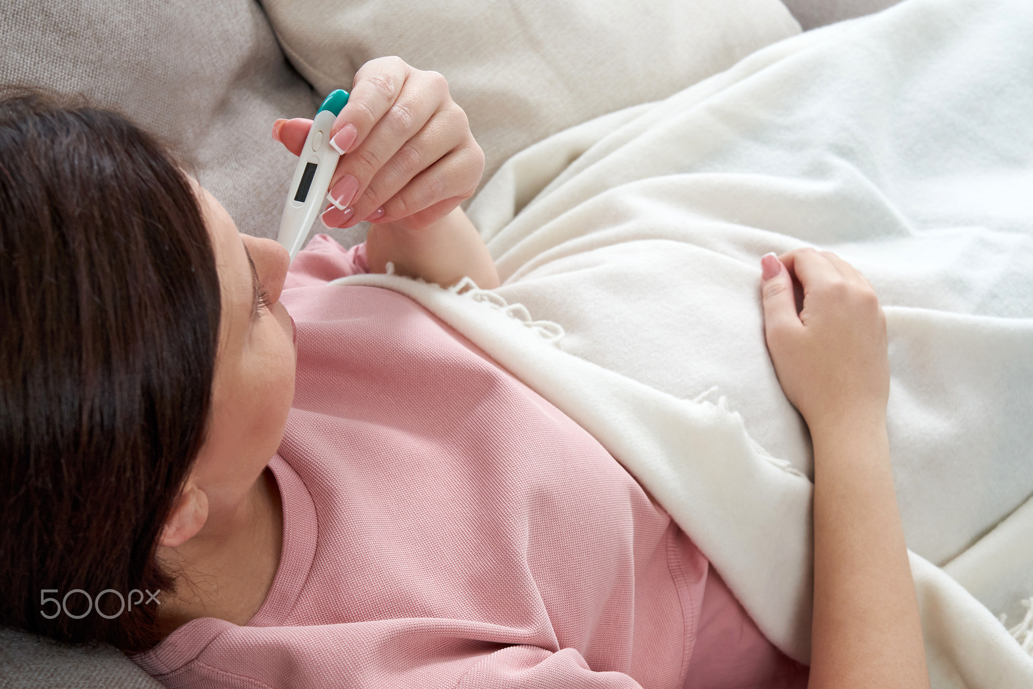 Woman holding a digital thermometer. Concept of fever, flue, virus and