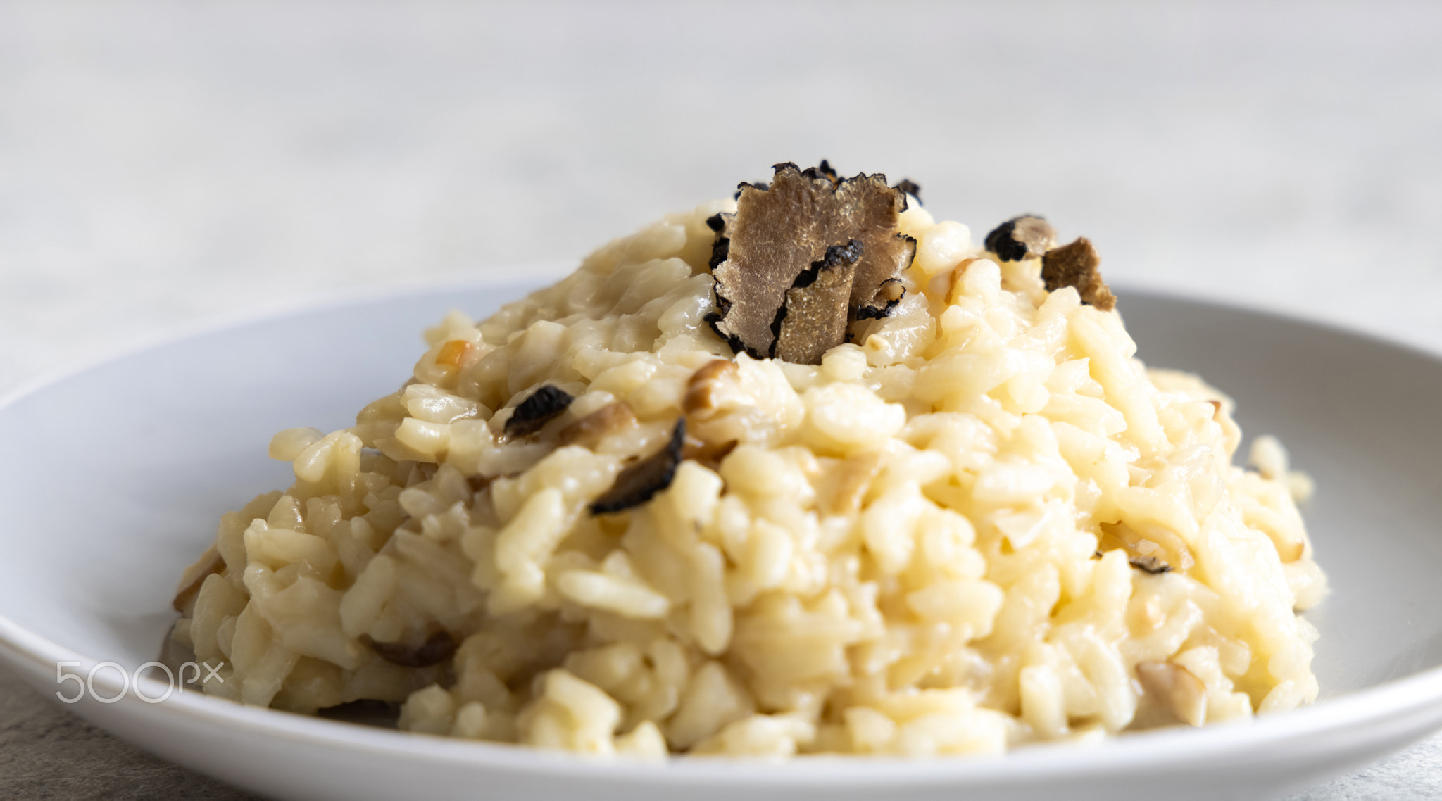 Risotto with porcini mushrooms and black truffles served in a plate top view, gourmet cousine