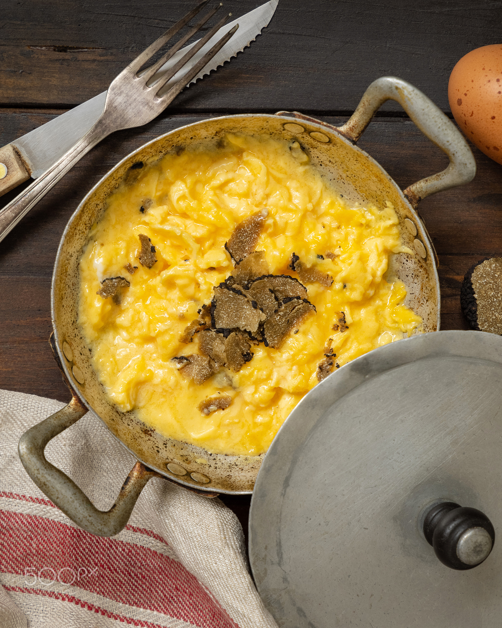 Scrambled eggs with fresh black truffles from Italy served in a frying pan, gourmet breakfast