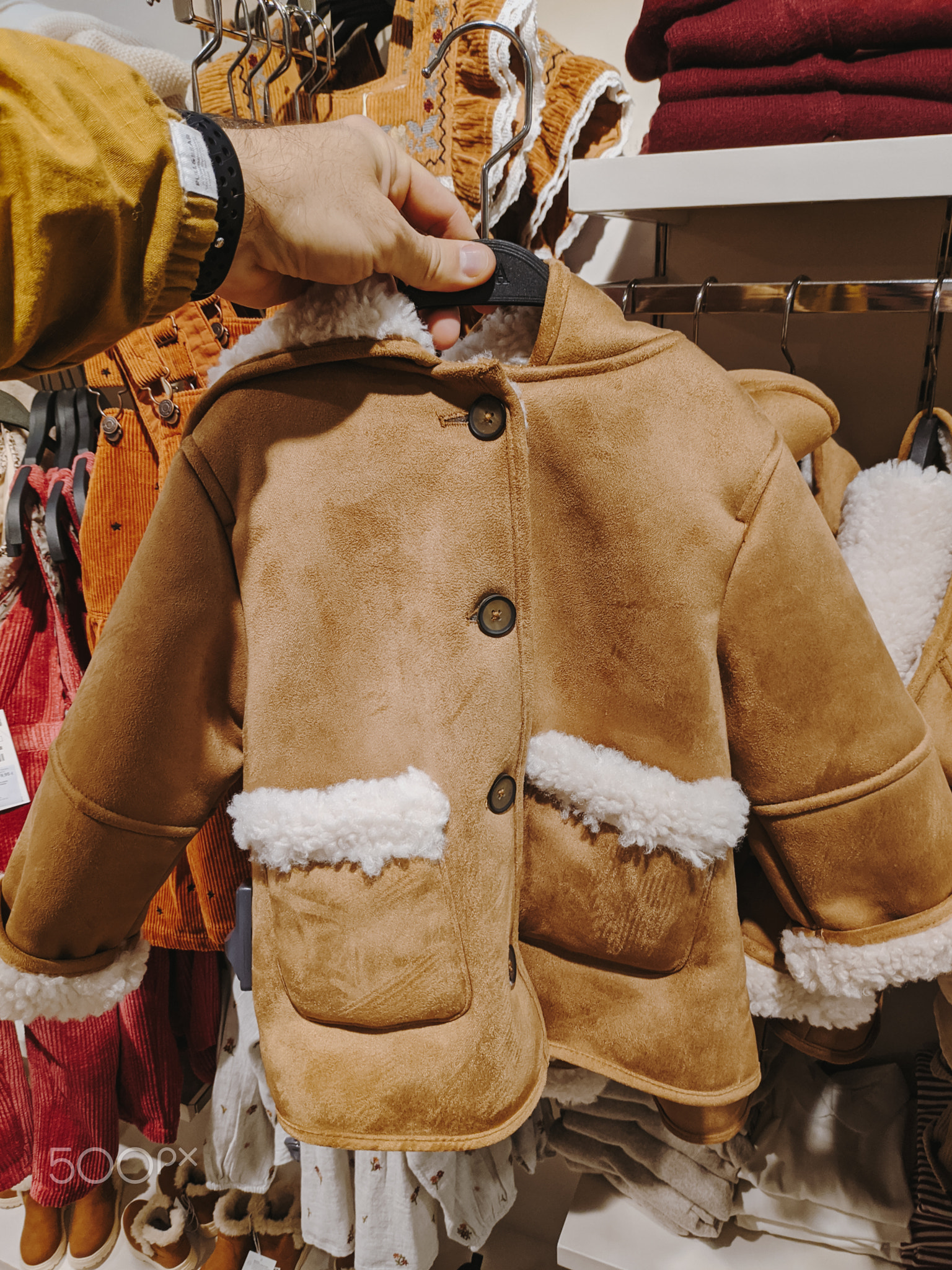 Budva, Montenegro - 01.08.22: Children sheepskin coat with fur hangs