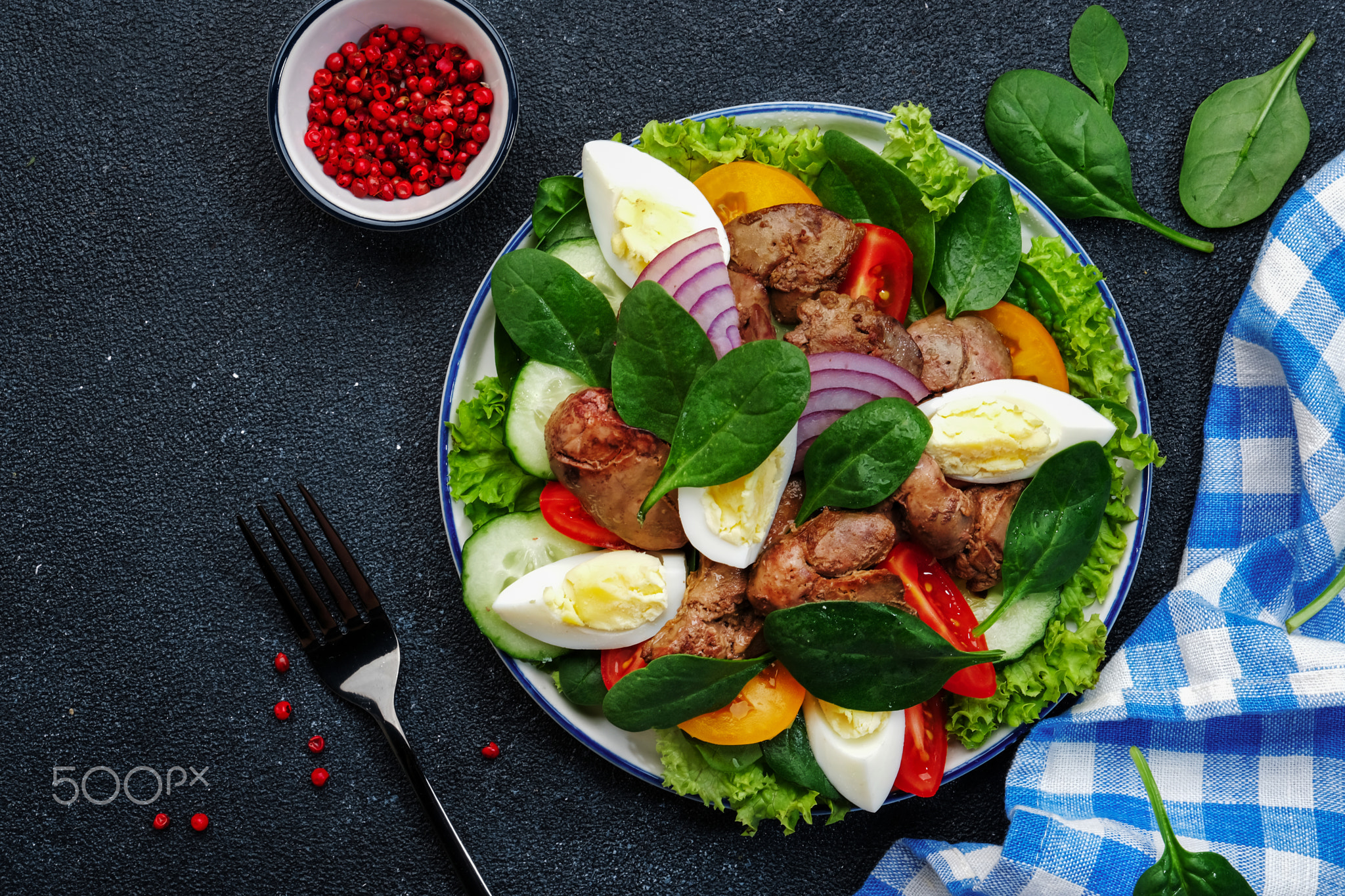 Perigord salad with chicken liver, tomatoes, cucumbers, eggs, lettuce and spinach