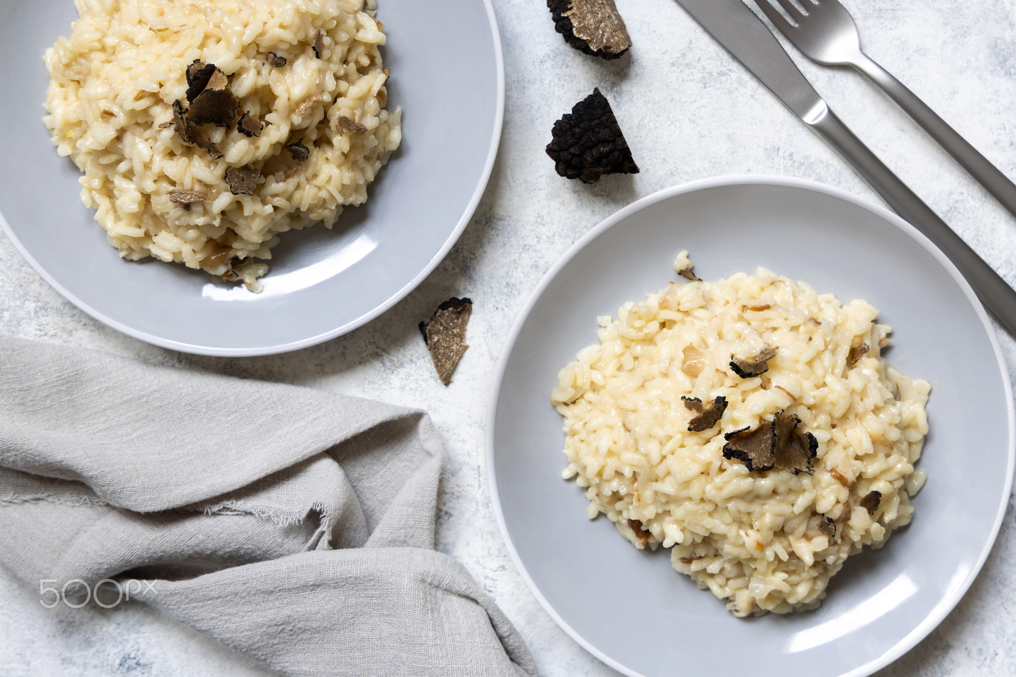 Risotto with porcini mushrooms and black truffles served in a plate top view, gourmet cousine