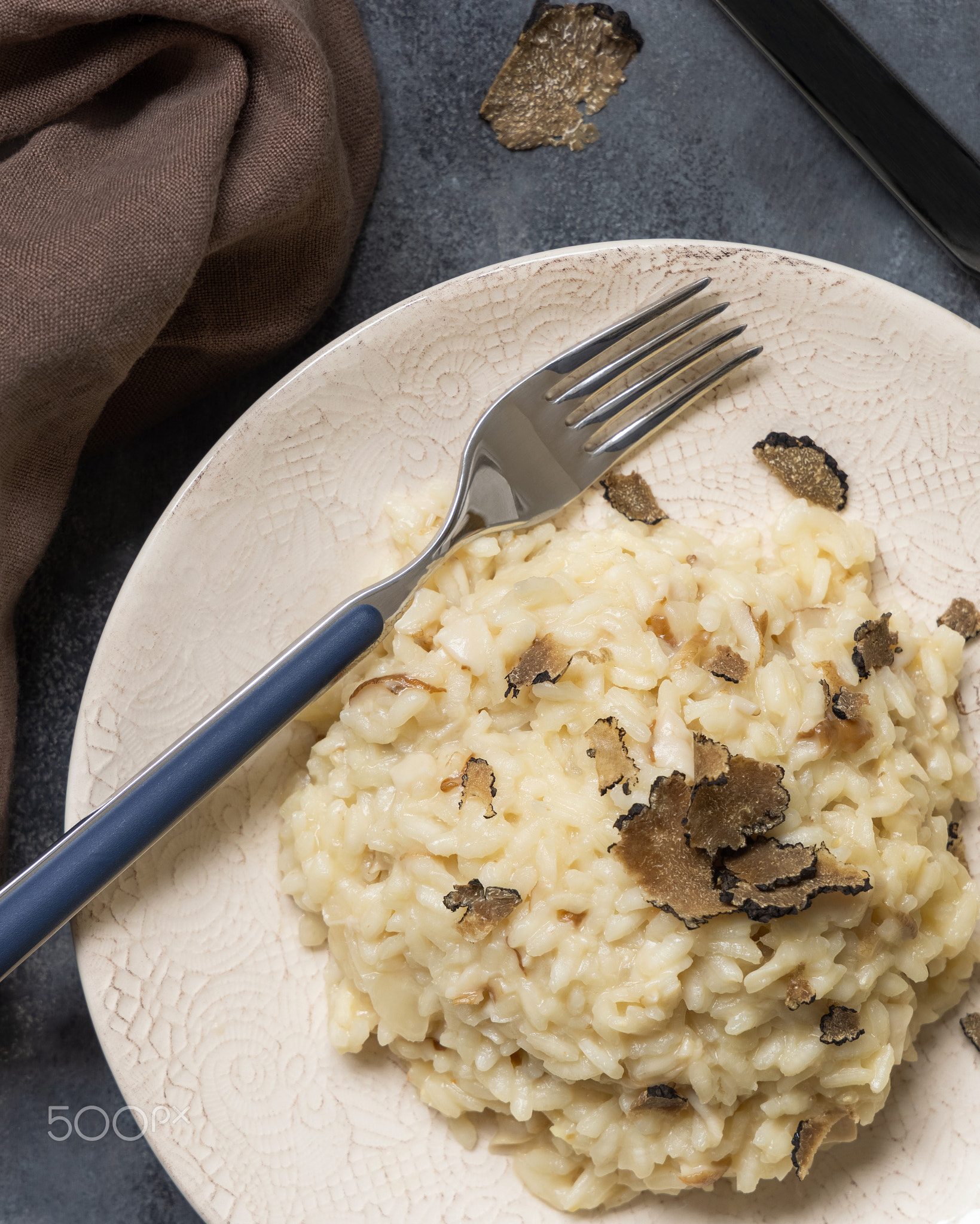 Risotto with porcini mushrooms and black truffles served in a plate top view, gourmet cousine