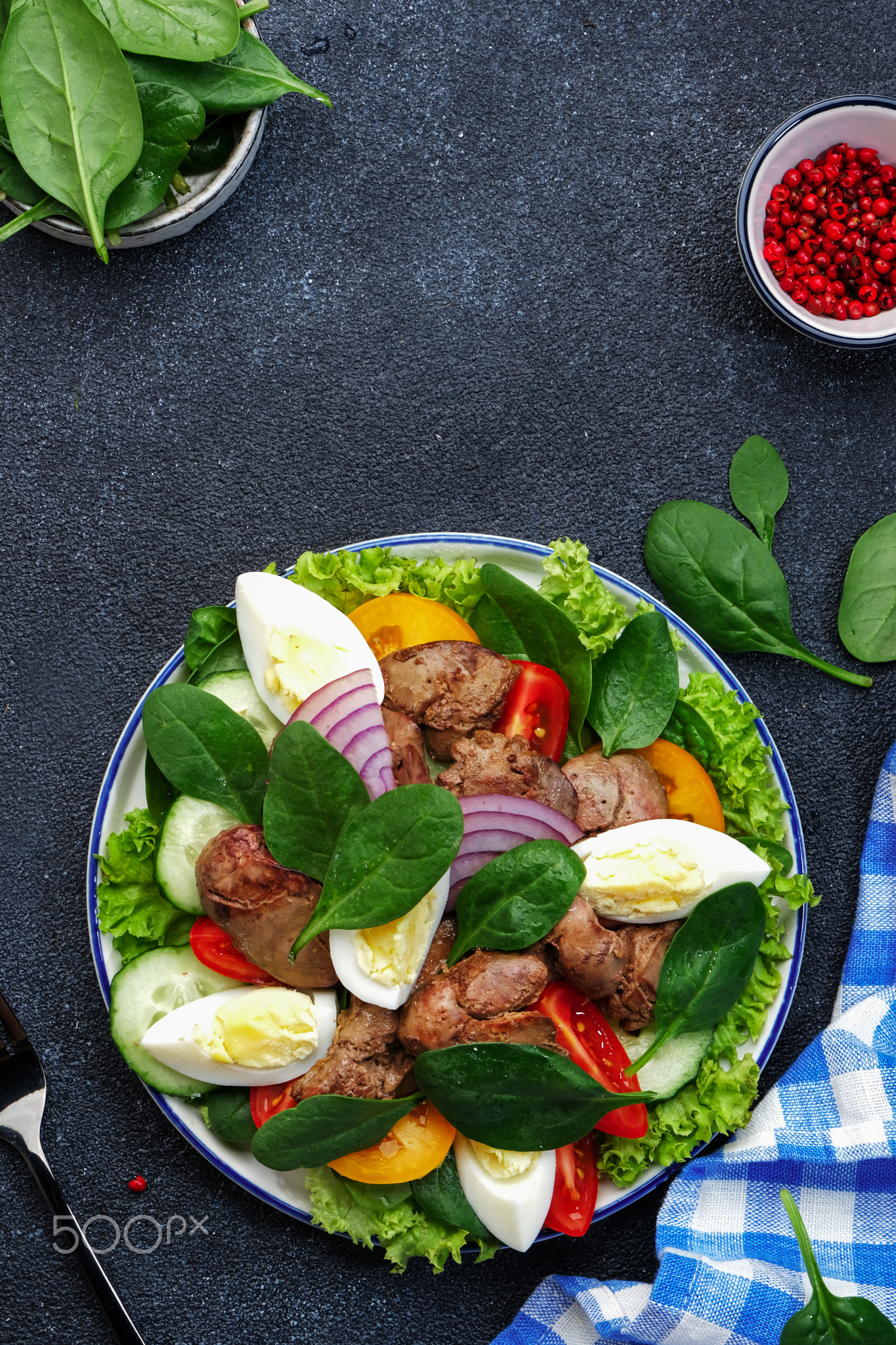 Perigord salad with chicken liver, tomatoes, cucumbers, eggs, lettuce and spinach