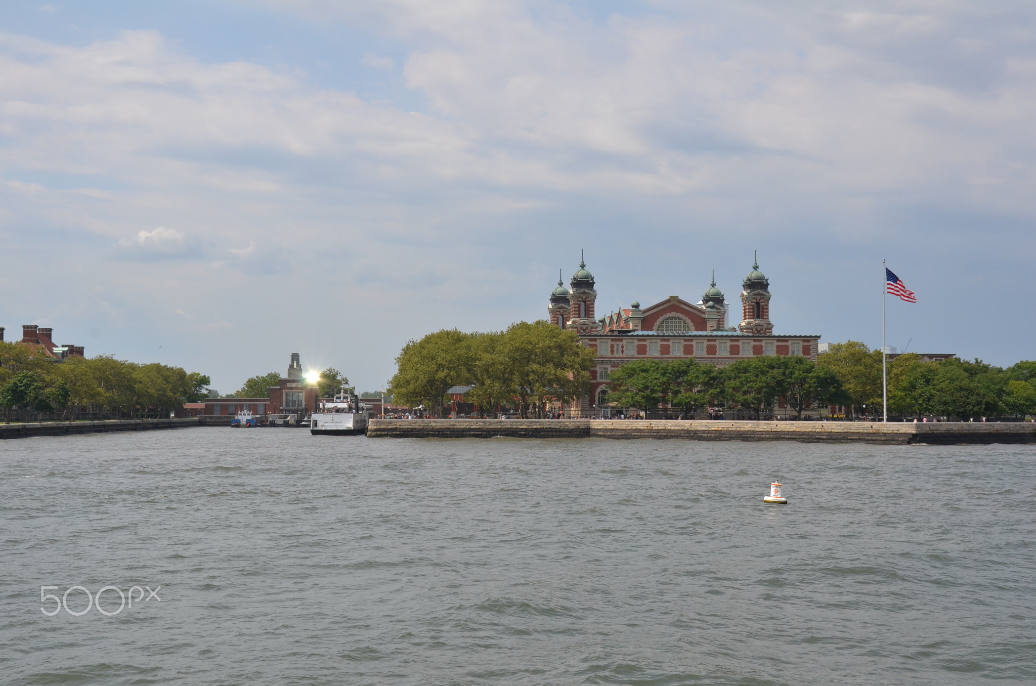 Ellis Island building and United States flag with water in New York