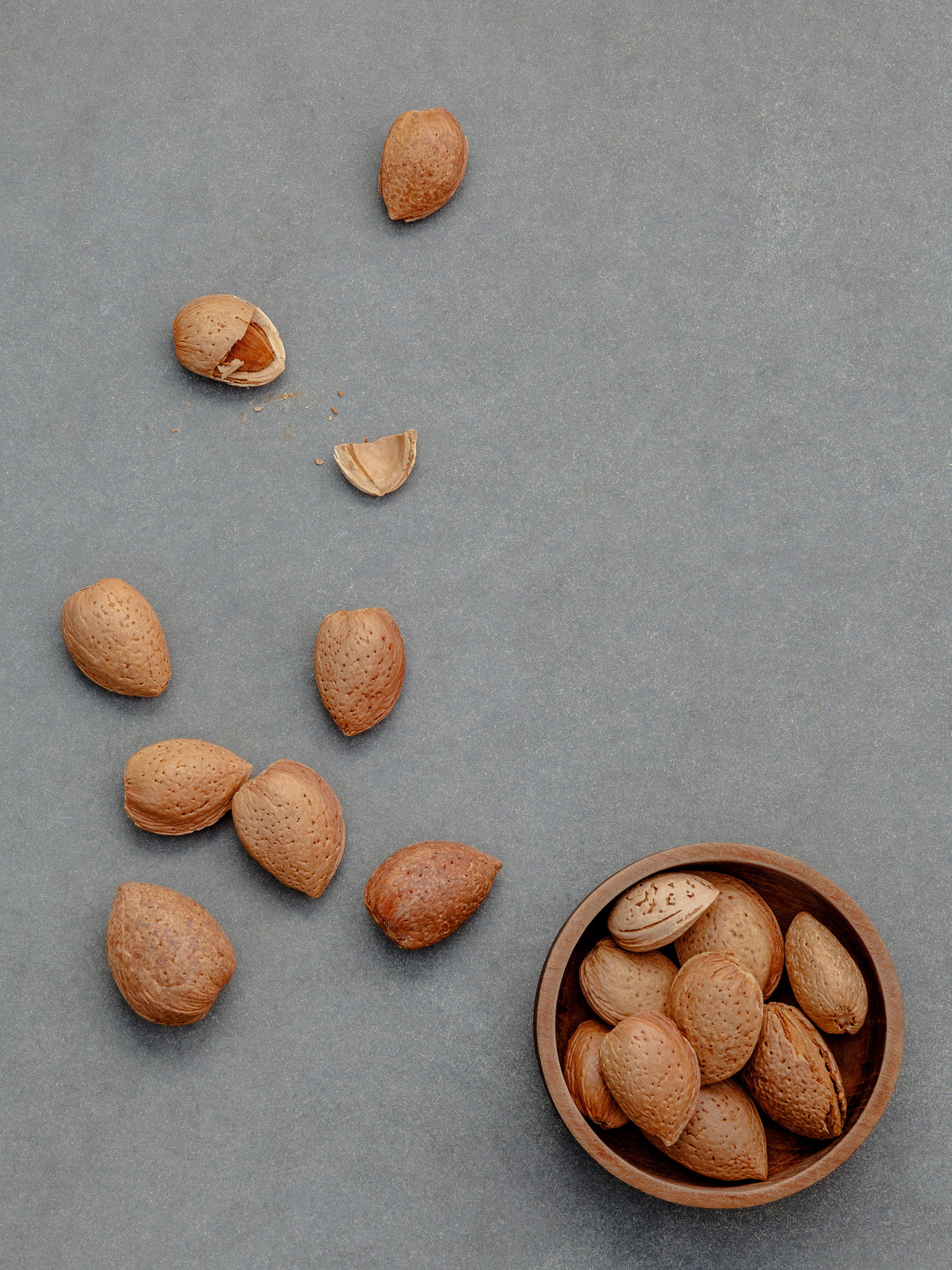 Almonds kernels and whole almonds on concrete background. Whole and chopped almond on concrete backg