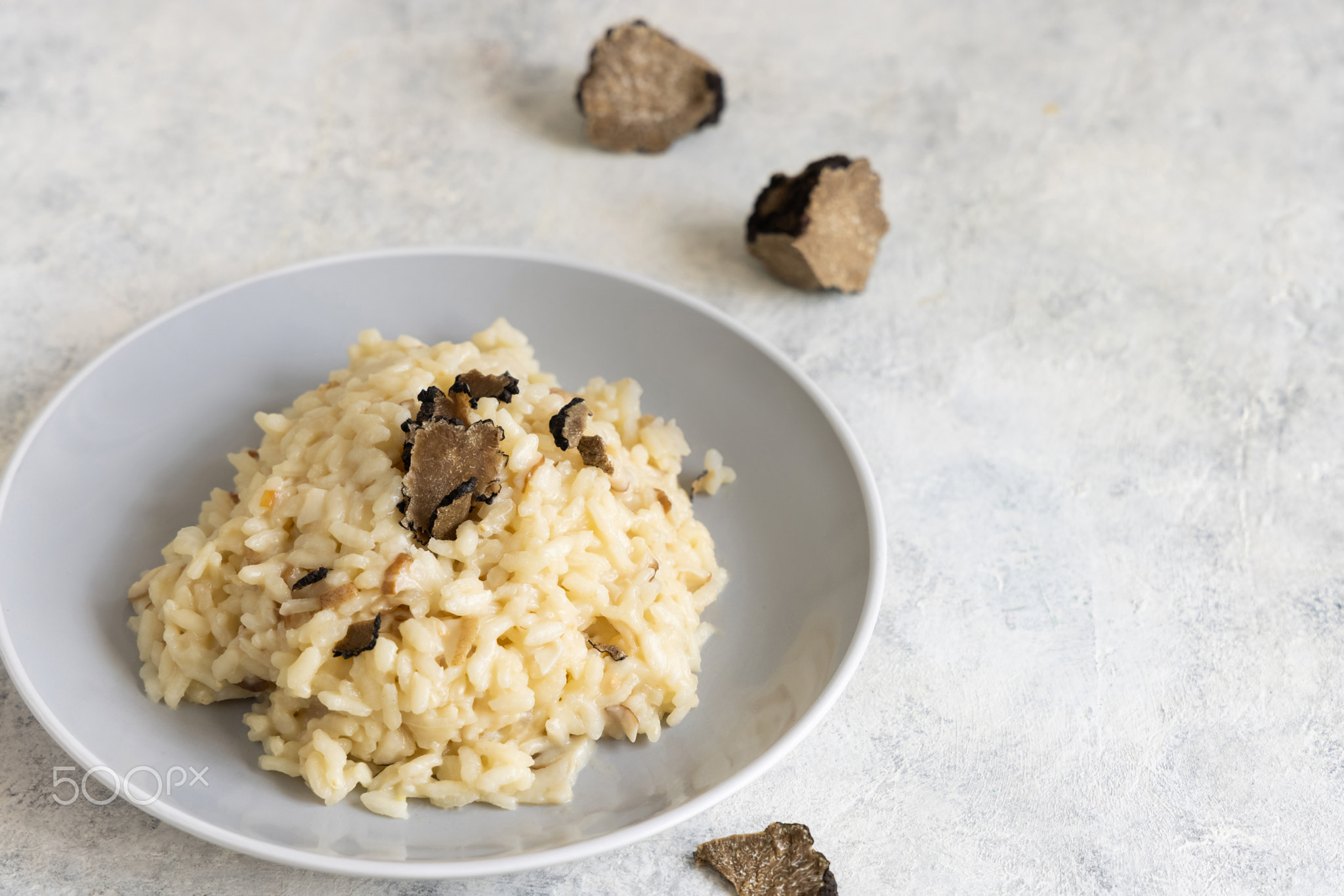 Risotto with porcini mushrooms and black truffles served in a plate top view, gourmet cousine