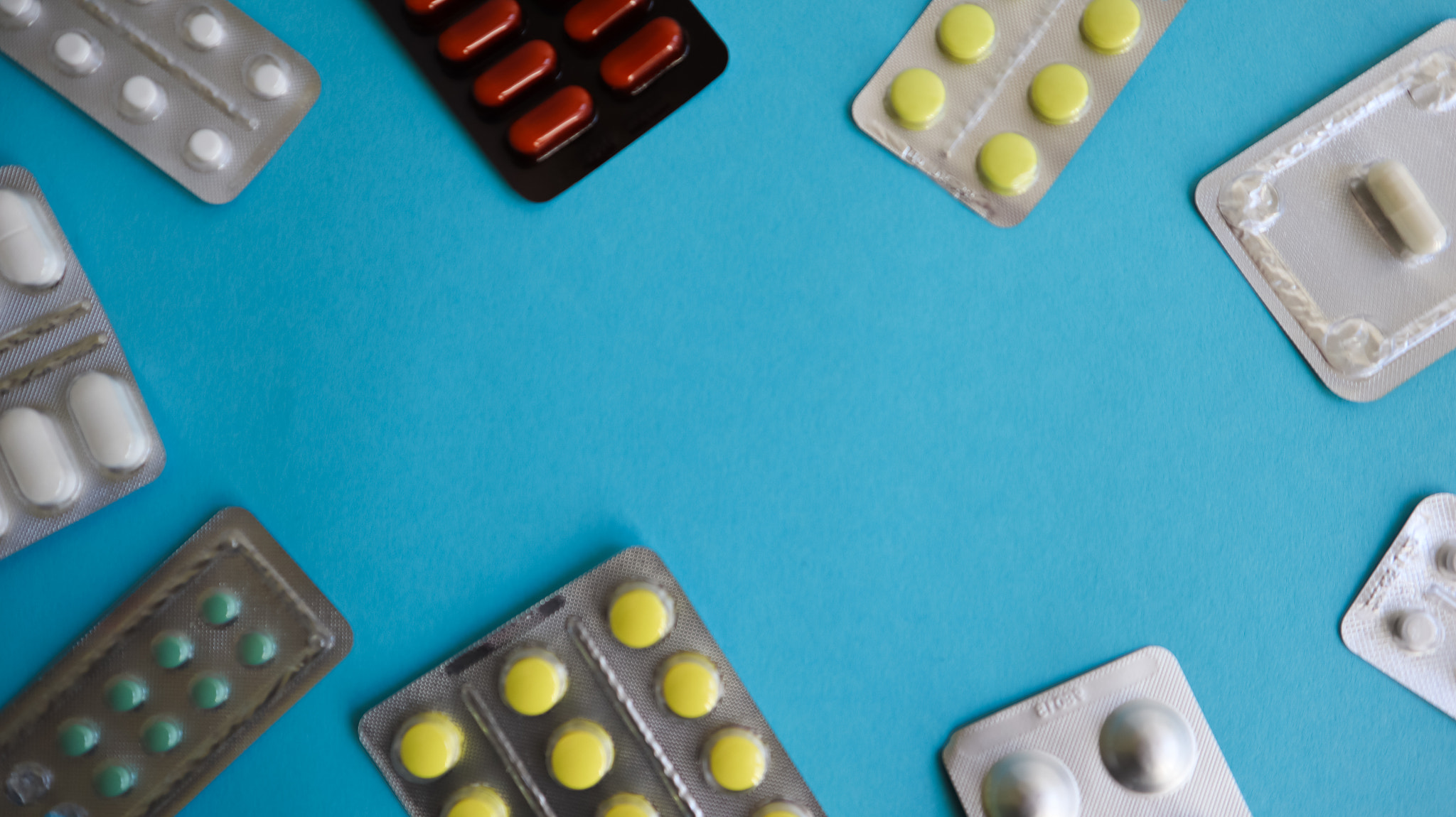 colored medicines and pills in packs on a blue background. Copy space. Pharmacology and medicine are