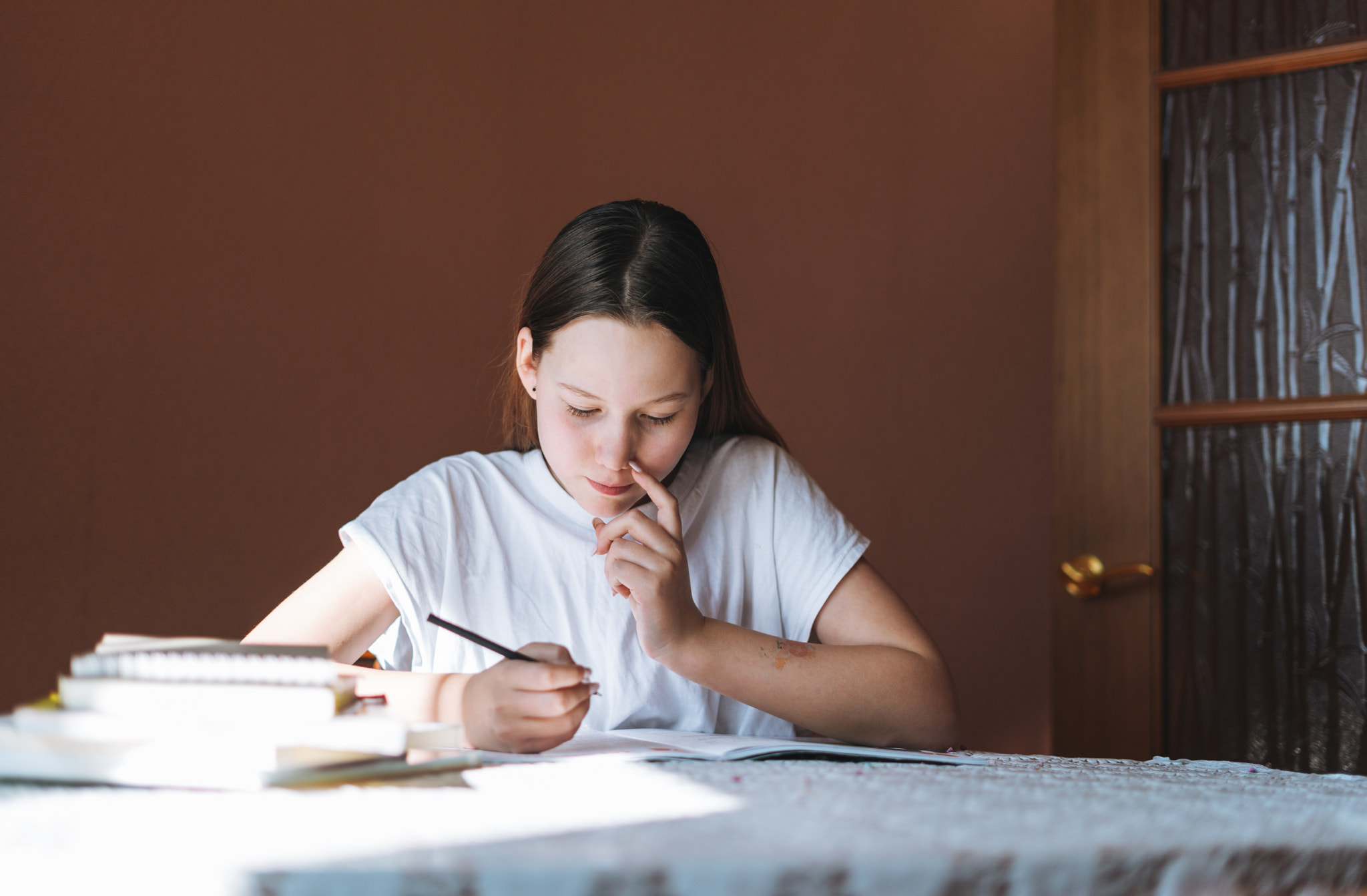 Teenage girl doing homework in room at home