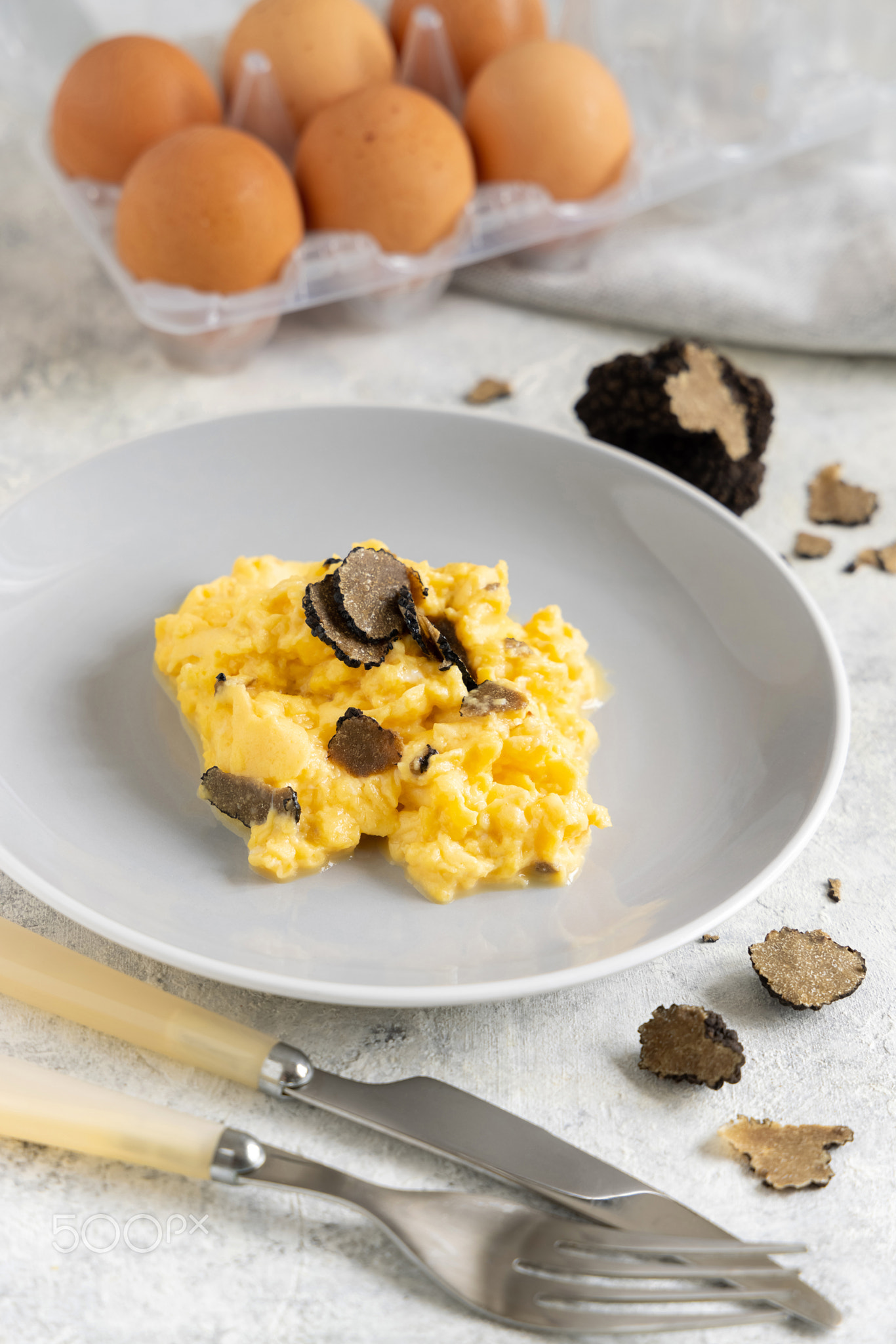 Scrambled eggs with fresh black truffles from Italy served in a plate close up, gourmet breakfast