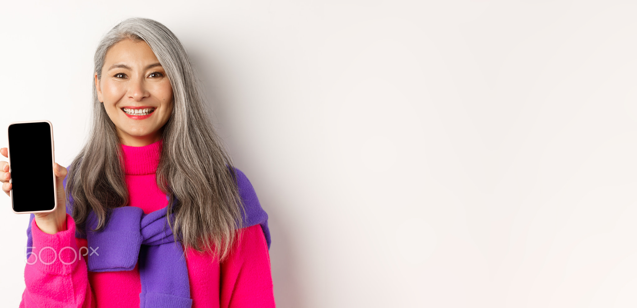 Online shopping. Close-up of smiling asian grandmother showing blank