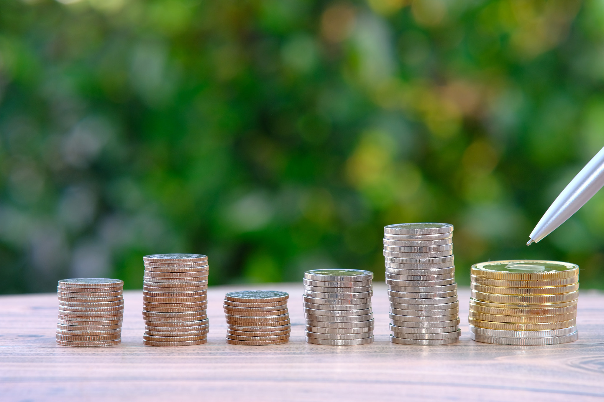 stack of coins on a green nature background