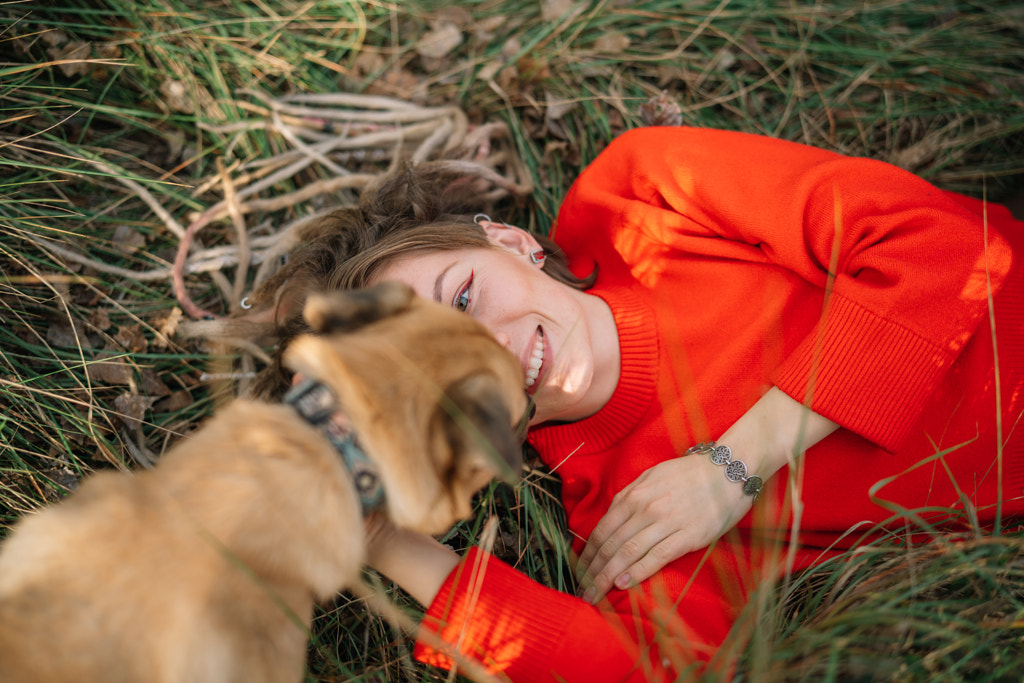 Young woman with dog lying on grass by Olha Dobosh on 500px.com