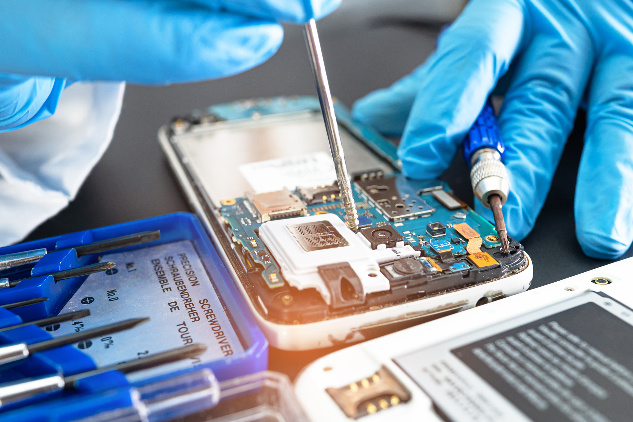 Technician repairing inside of mobile phone by soldering iron. Integrated Circuit. the concept of da