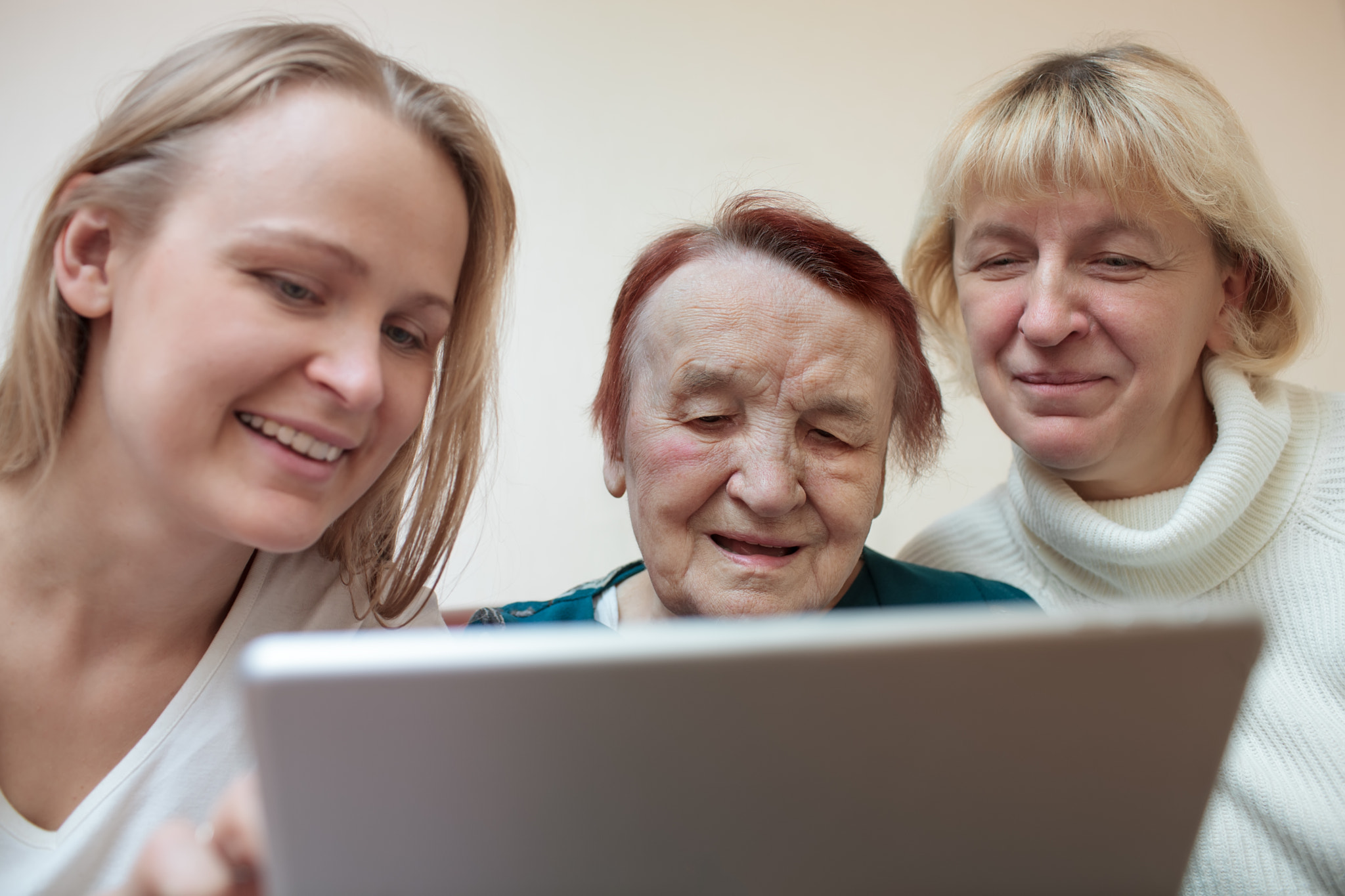 Three women using a smart tablet