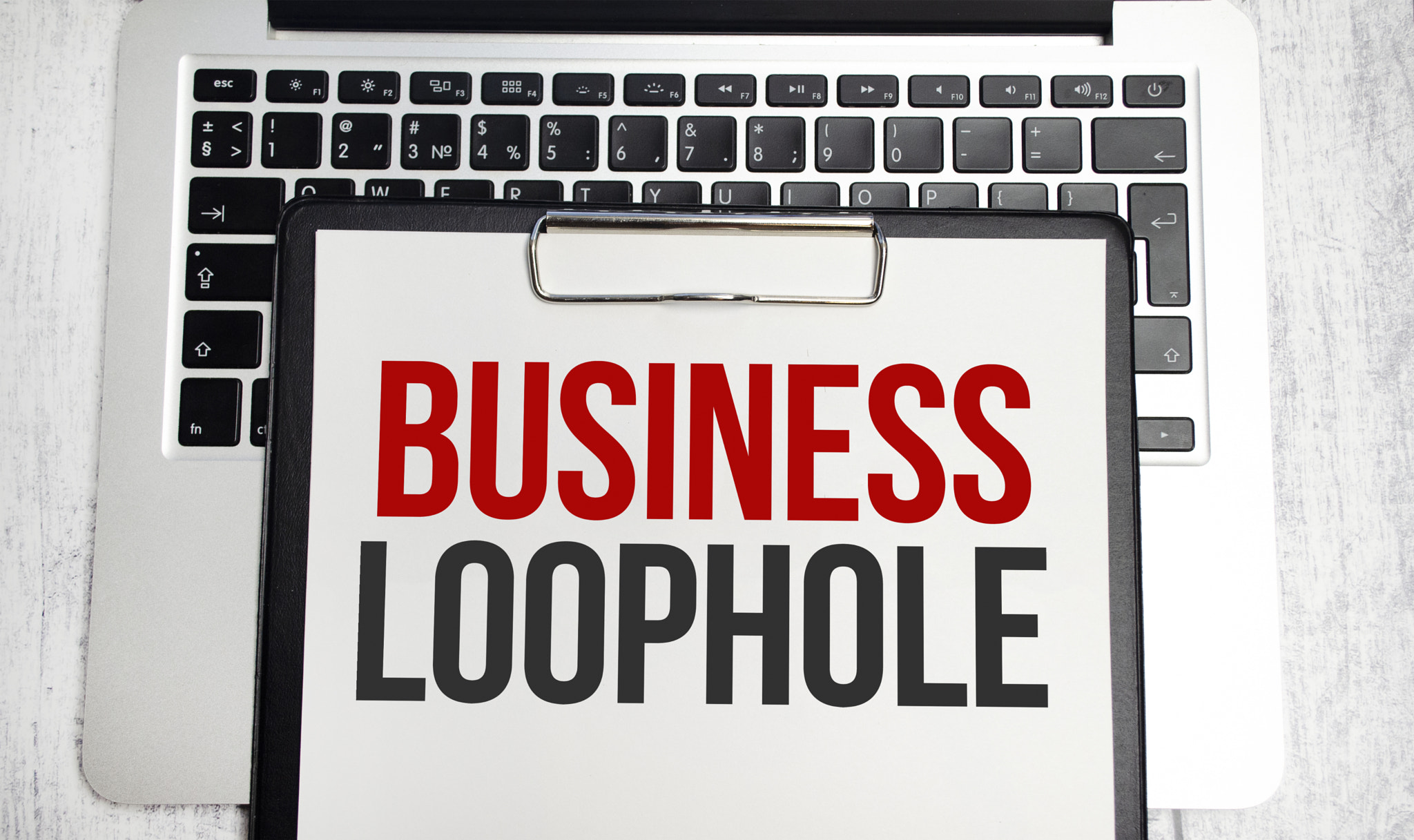 business loophole words on paper tablet on laptop