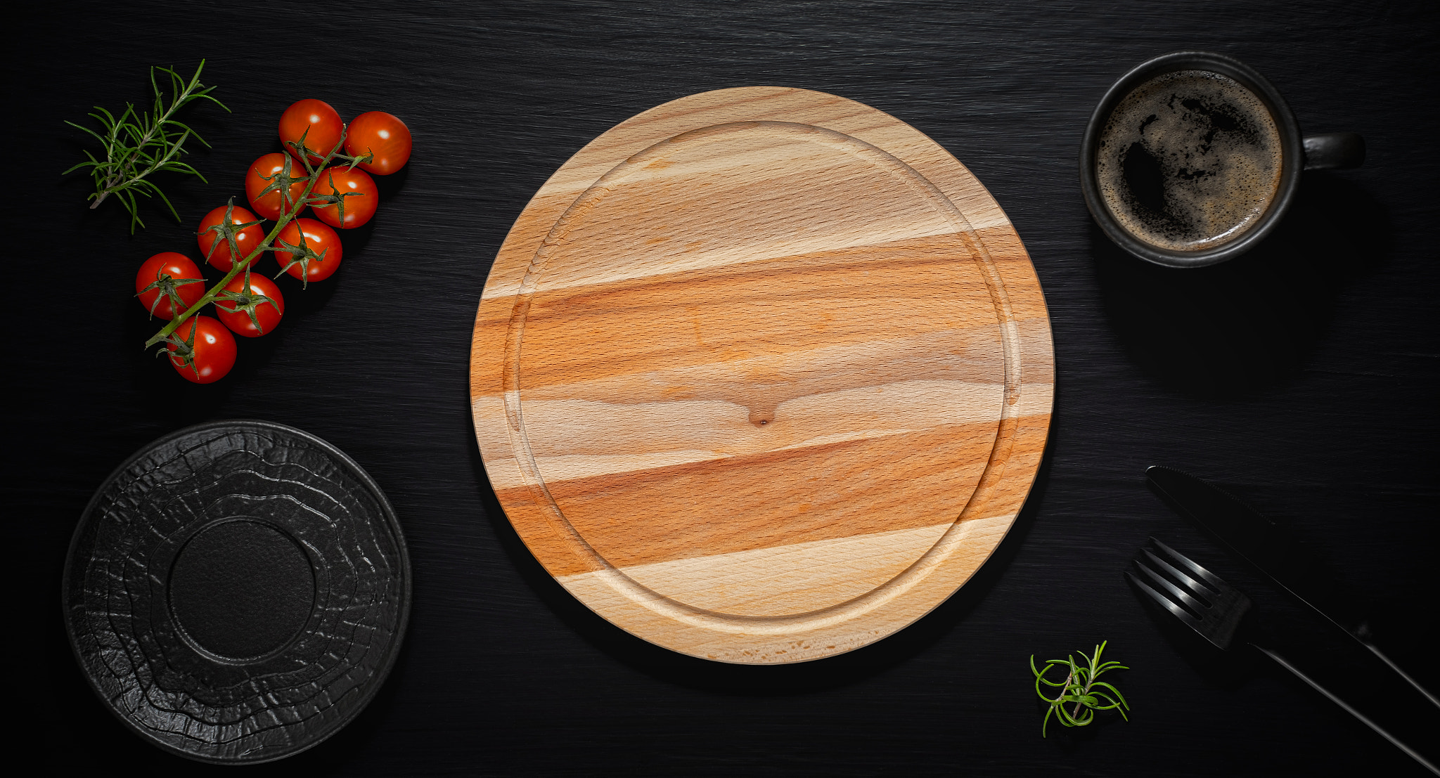 Empty wooden plate and coffee cup on black table. Top view, with copy space