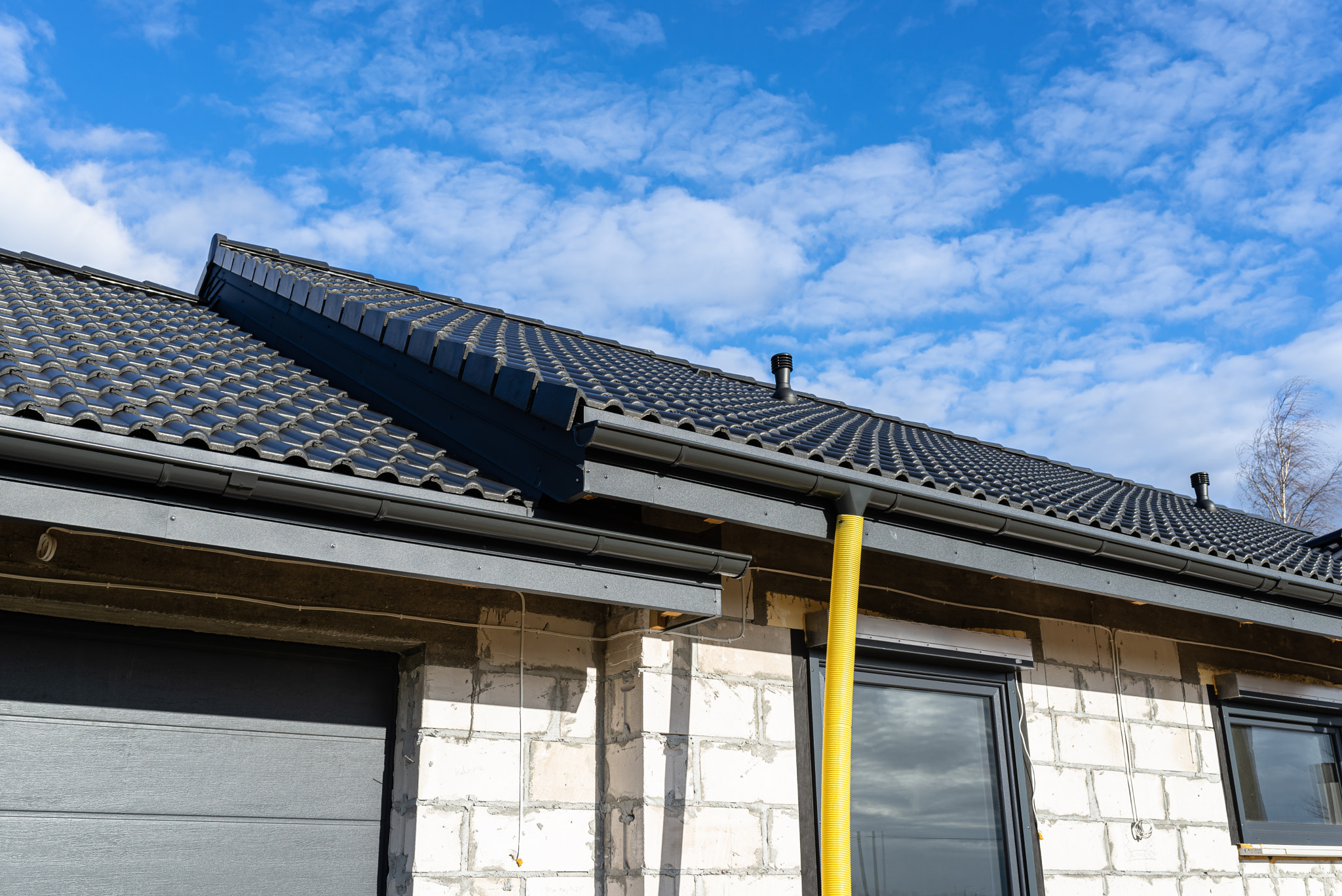 100mm diameter yellow PVC pipe connected to the end the gutter on the roof protected against water