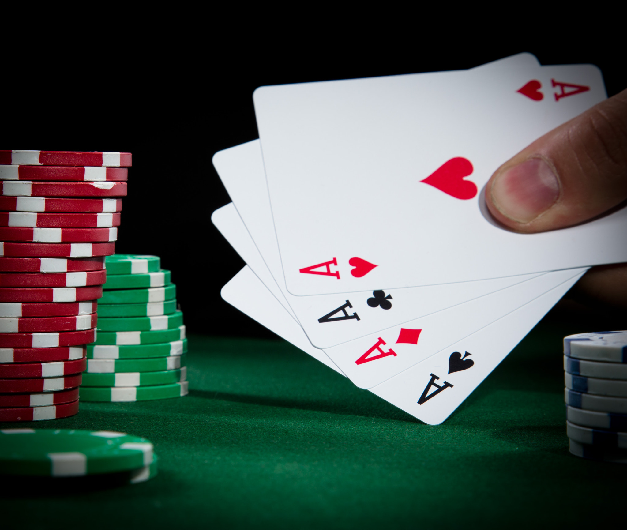 Four aces on a green poker table