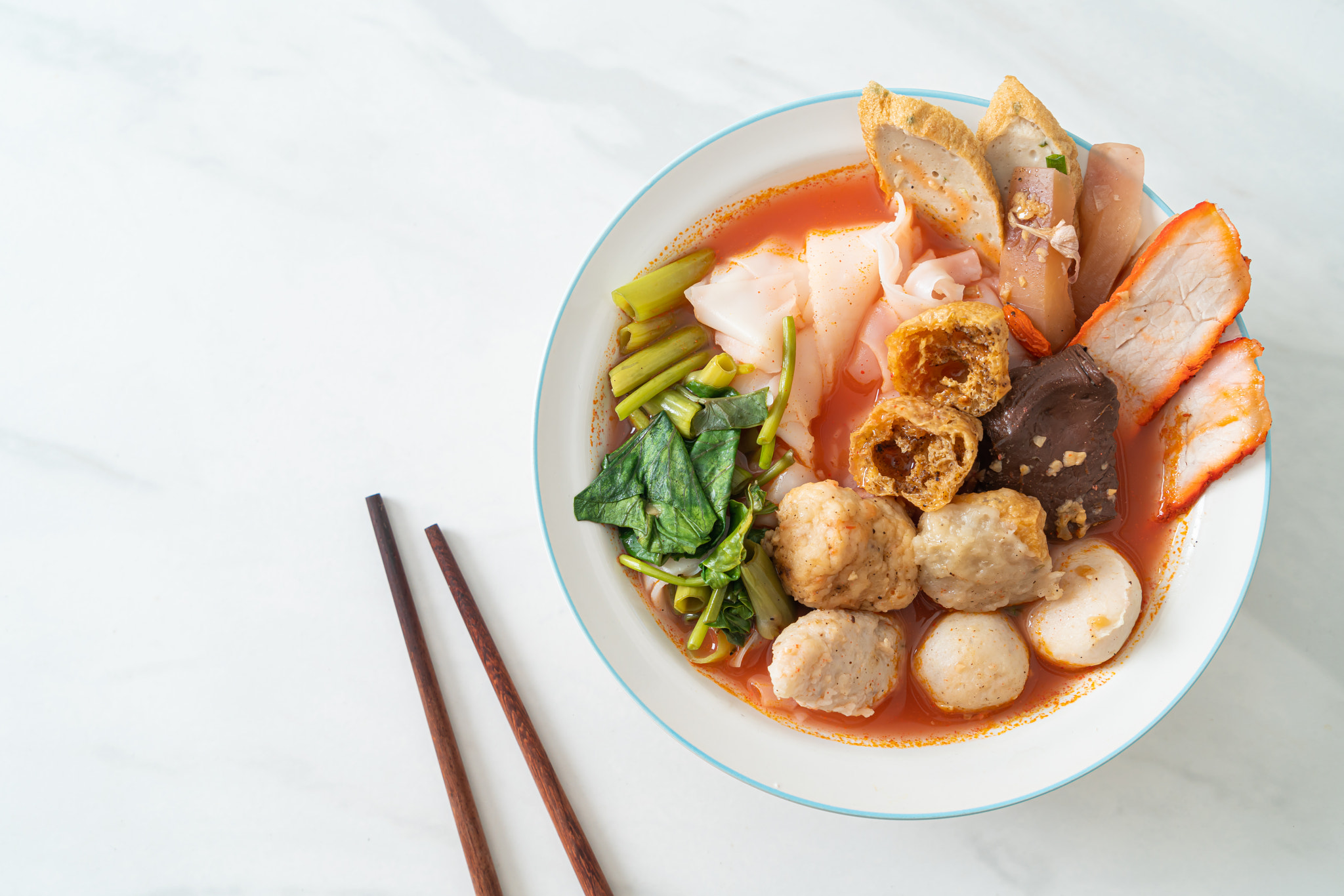 noodles with meatballs in pink soup