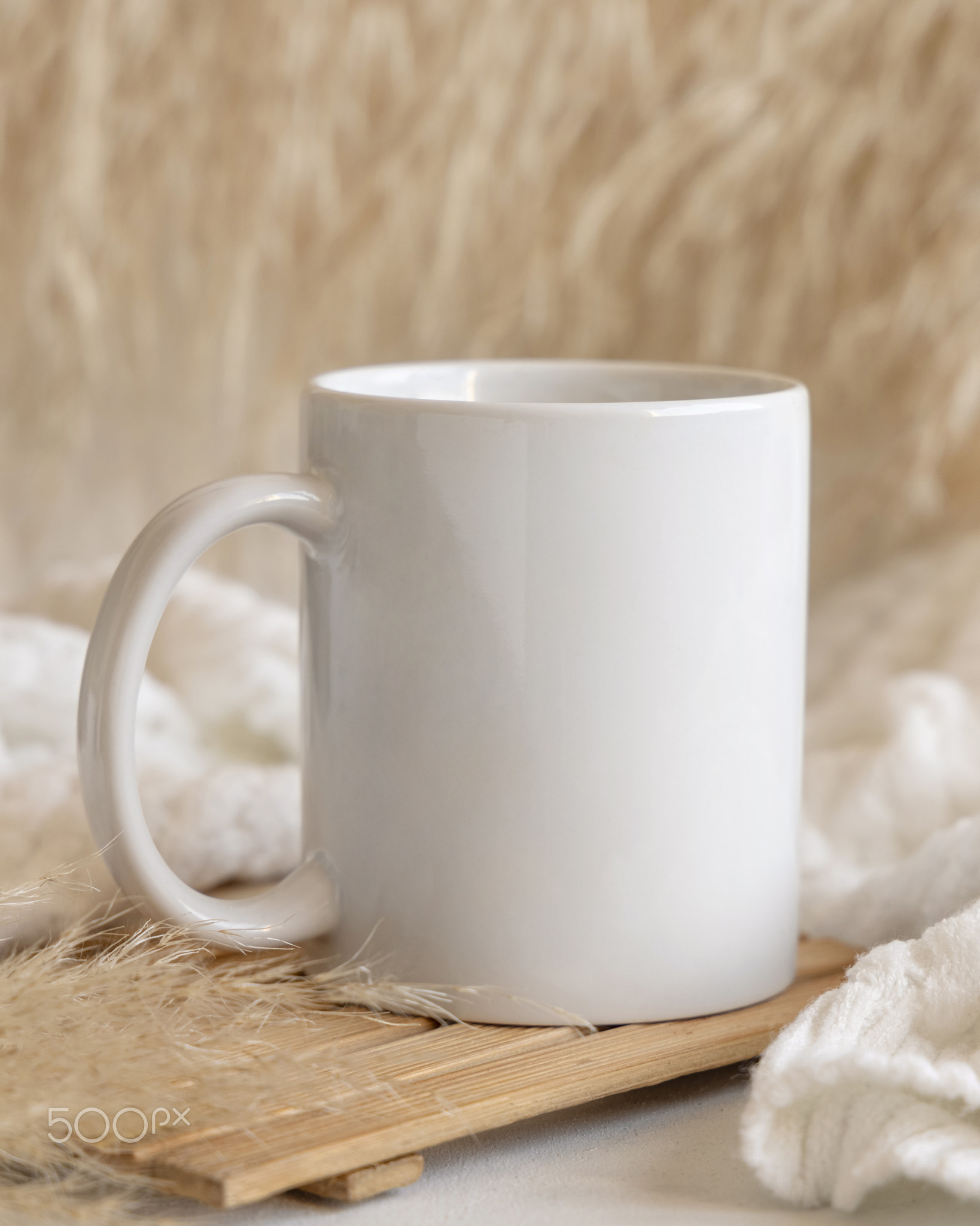 White coffee mug on wooden tray near pampas grass and cosy sweater, Close up, mock up