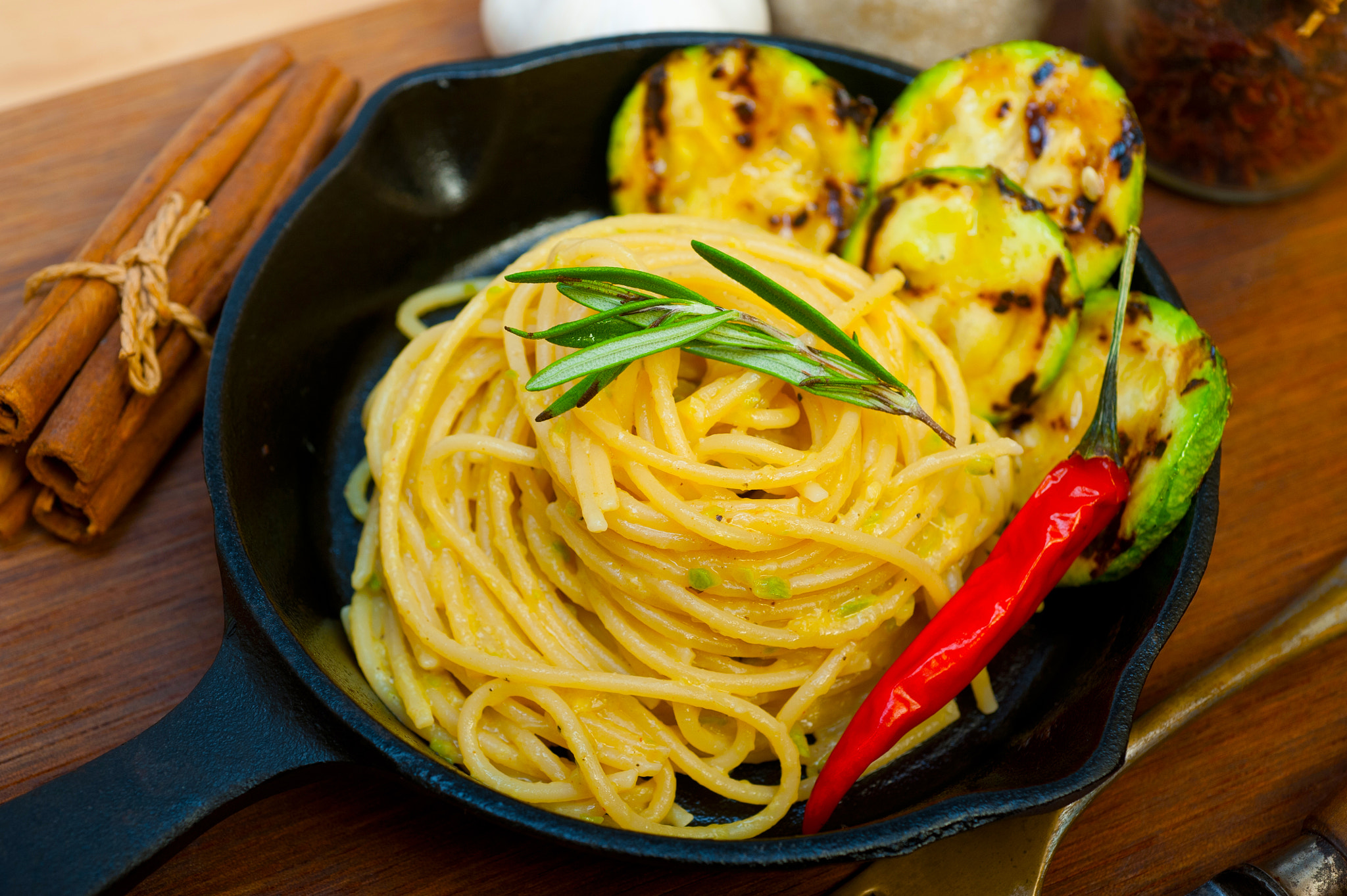 italian spaghetti pasta with zucchini sauce on iron skillet