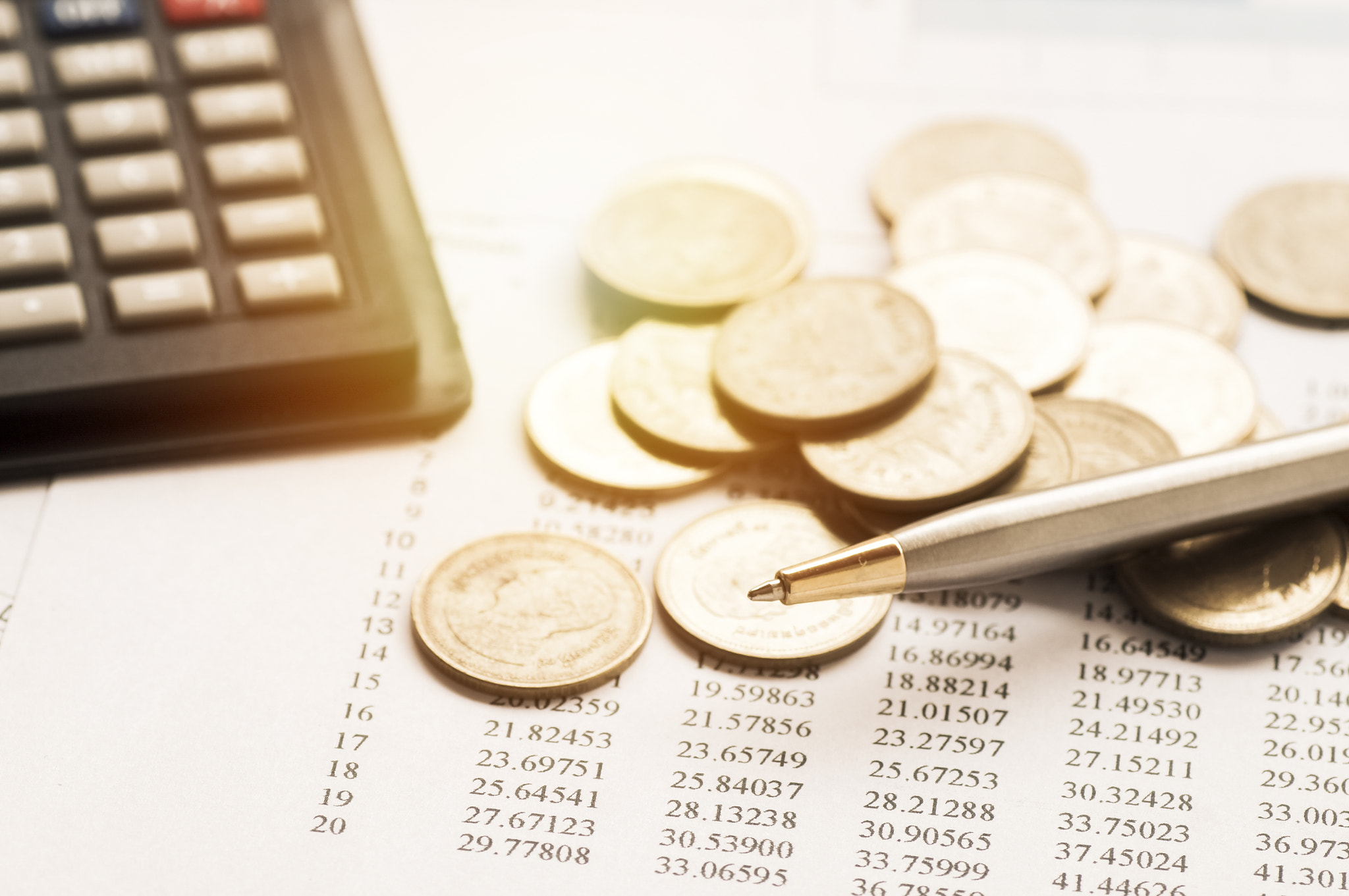 coins, pile of money on summary report paper of finance and account bank with calculator and pen