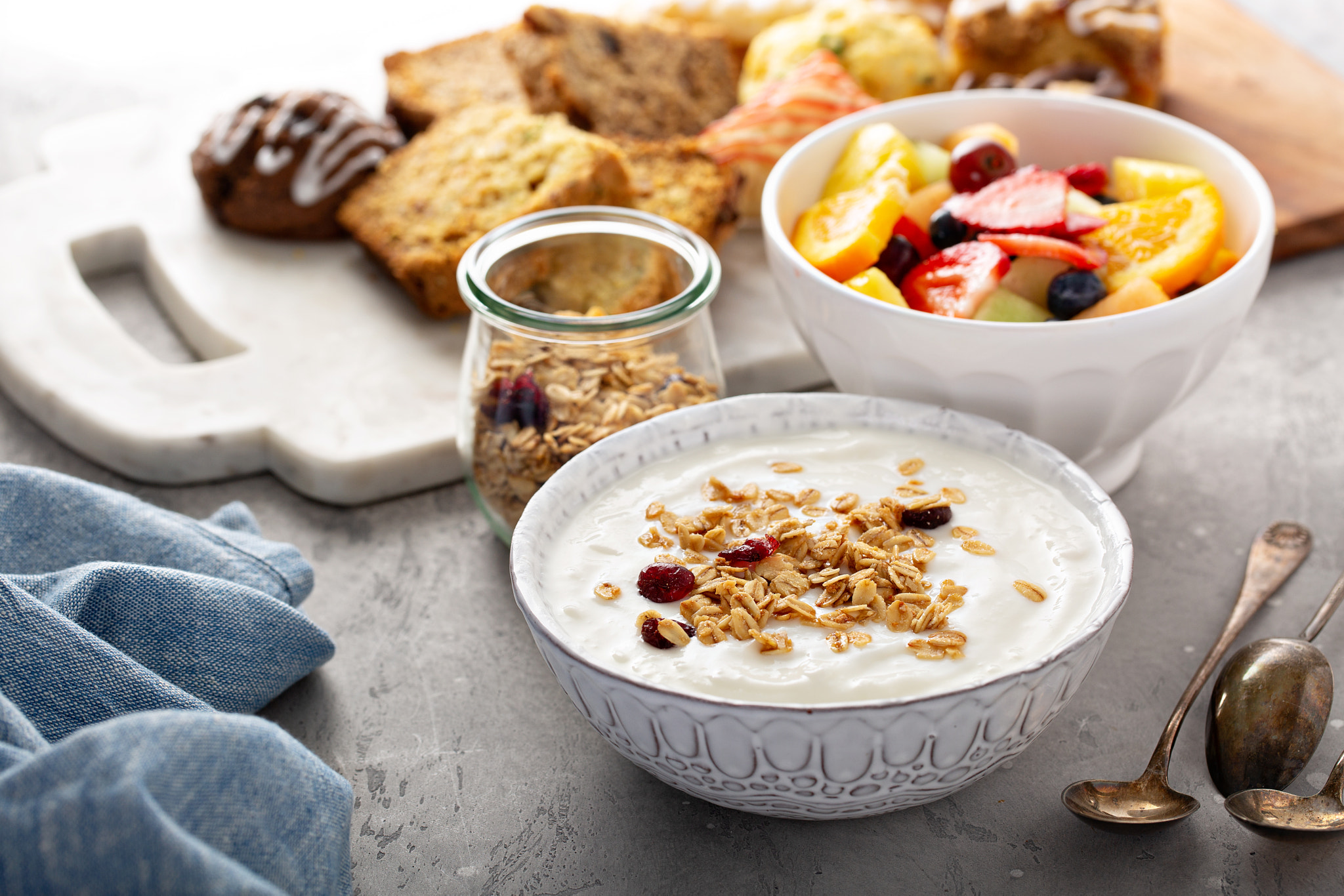 Breakfast table with granola, yogurt and fruit