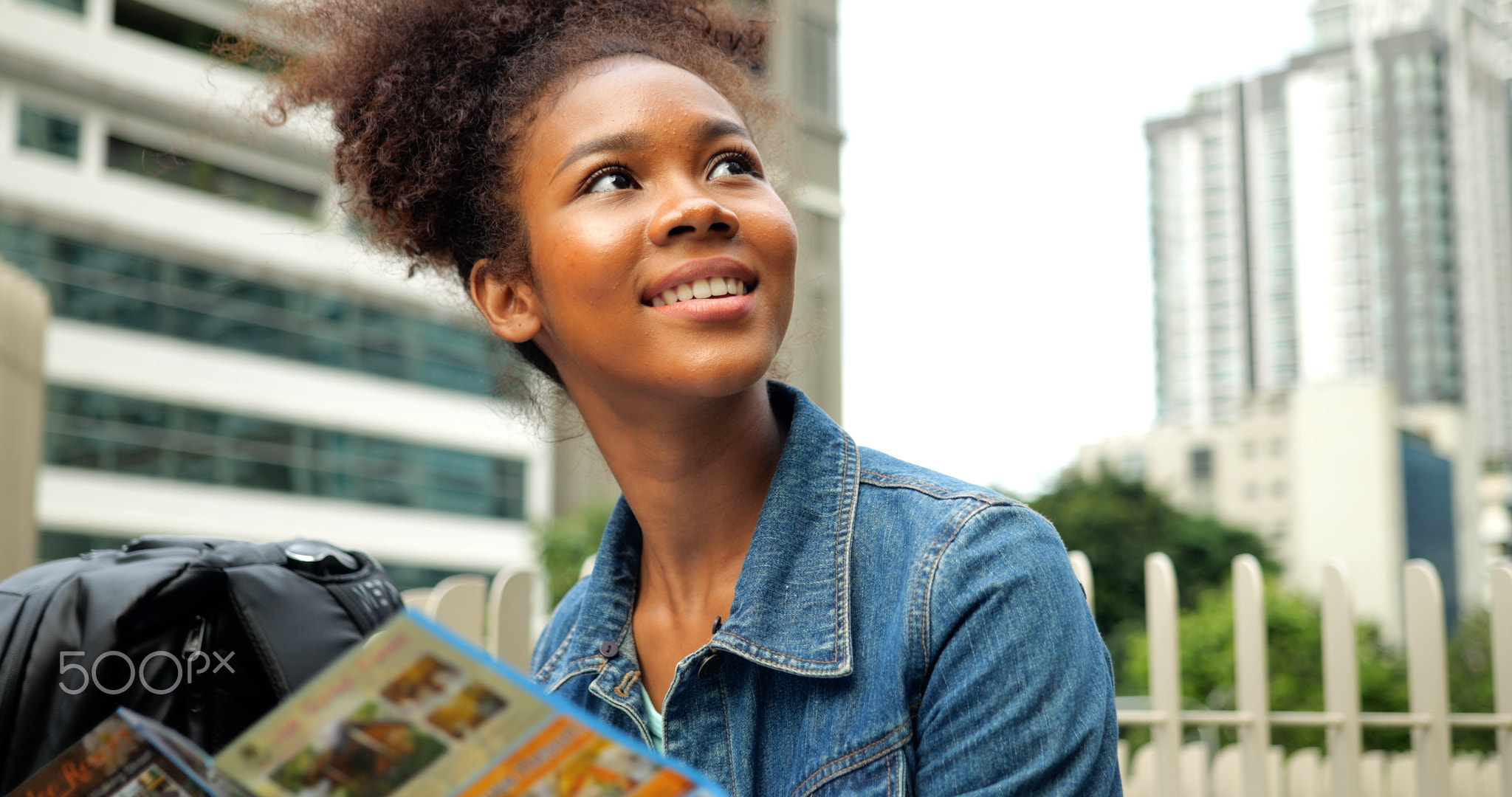 Portrait of smiling happy woman walking in street with backpack