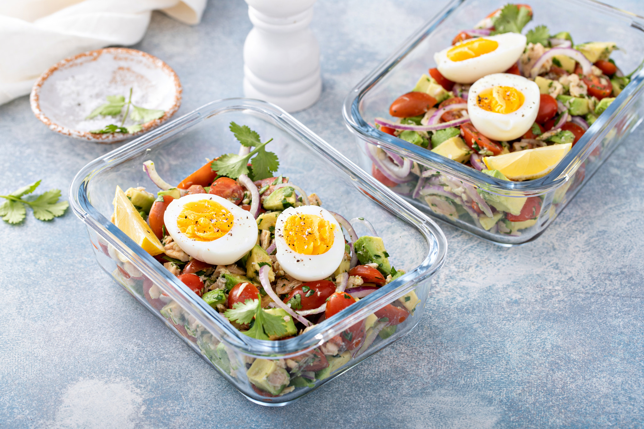 Meal prep containers with avocado tuna salad and boiled egg