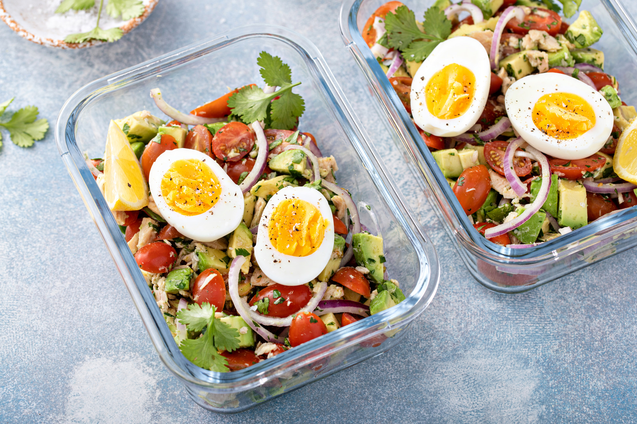 Meal prep containers with avocado tuna salad and boiled egg