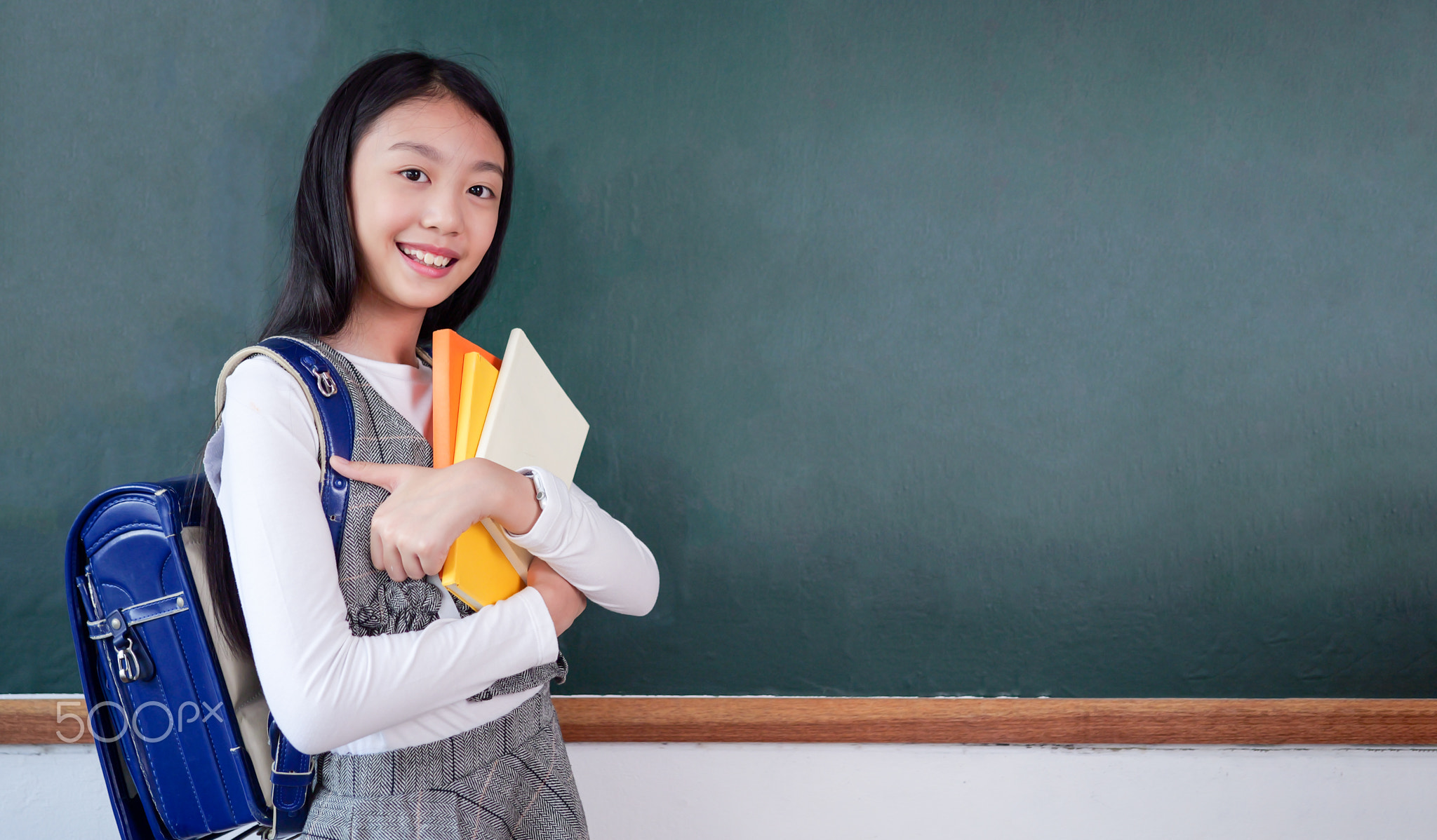 Student studying and reading textbook with happiness in classroom