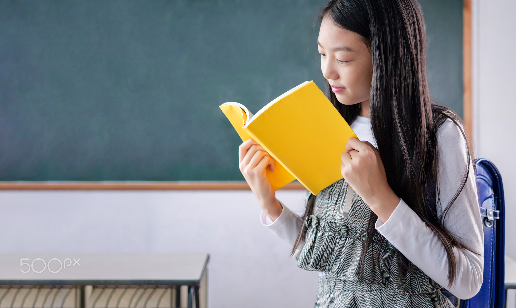 Student studying and reading textbook with happiness in classroom