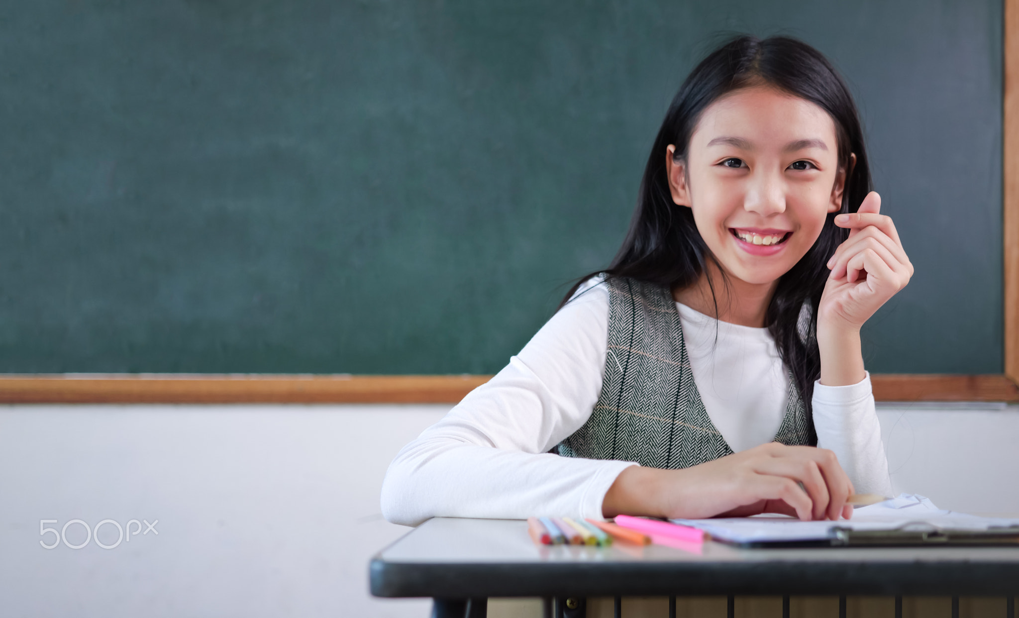 Student studying and reading textbook with happiness in classroom