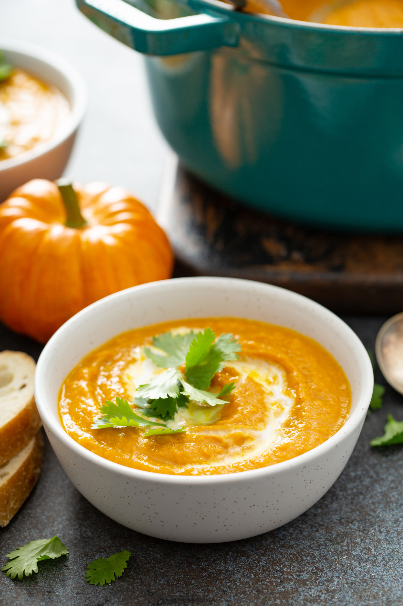 Pumpkin soup served with cream and cilantro