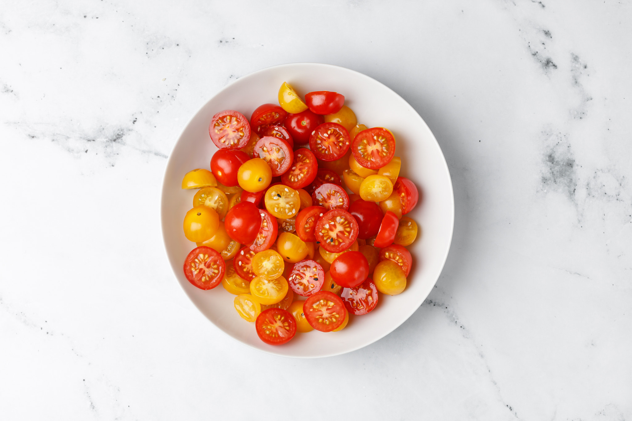 Diet and healthy vegetable salad with cherry red and yellow tomatoes on white plate and marble backg
