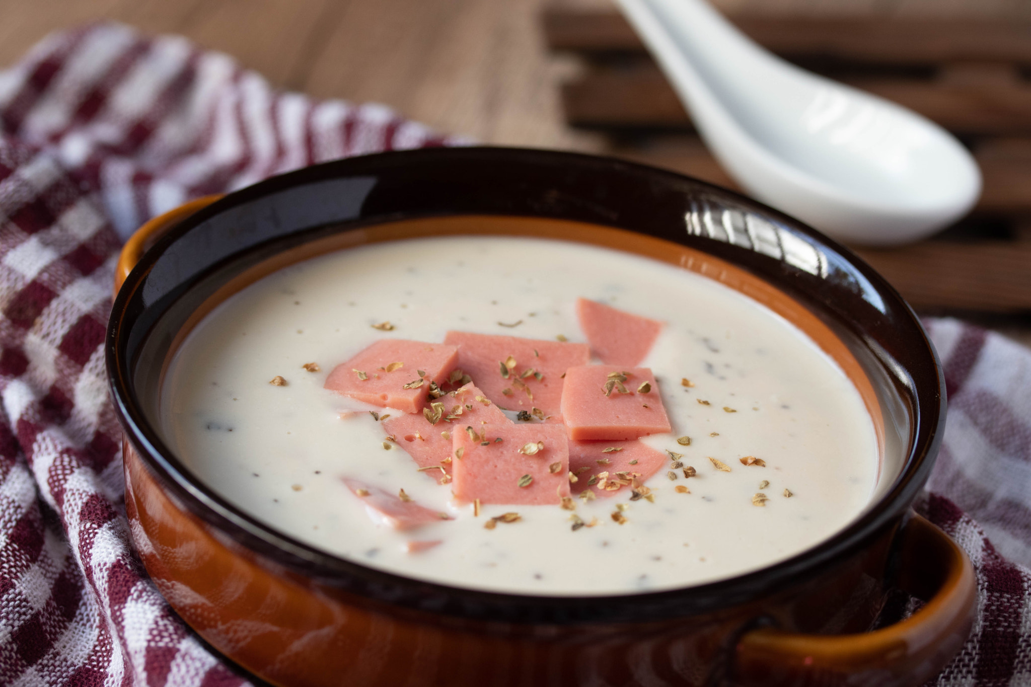 cheese soup with vegetables and ham with toast close-up on the table. horizontal sprinkle oregano in