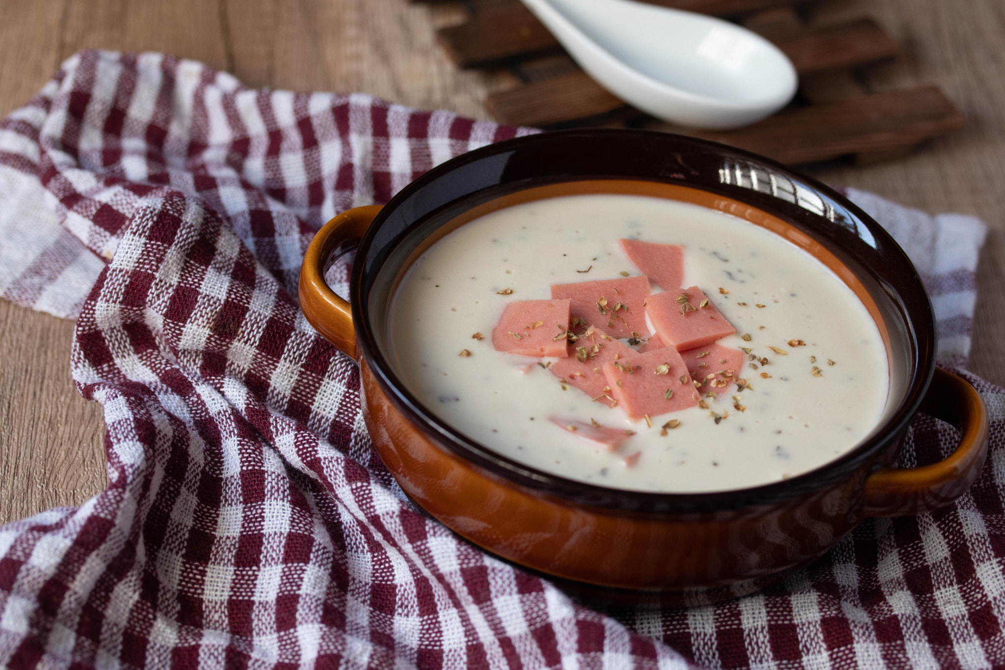 cheese soup with vegetables and ham with toast close-up on the table. horizontal sprinkle oregano in