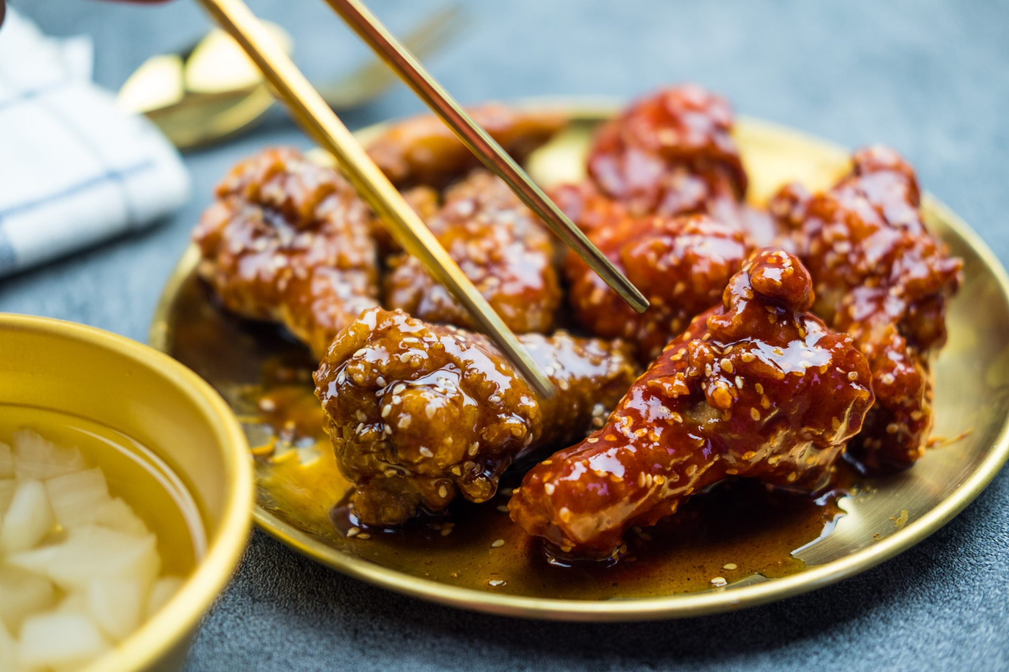 Deep fried chicken wing with garlic sauce and spicy sauce in Korean style served with pickled radish