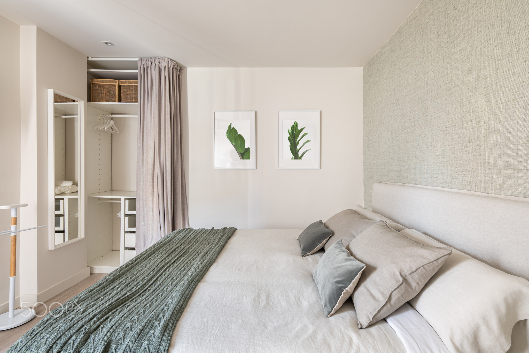 Comfortable bright bedroom with double bed and an empty wardrobe for