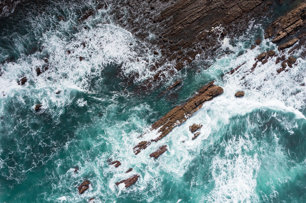 Vue aérienne des vagues dans la mer éclaboussant sur le rivage rocheux par Peter van Haastrecht sur 500px.com