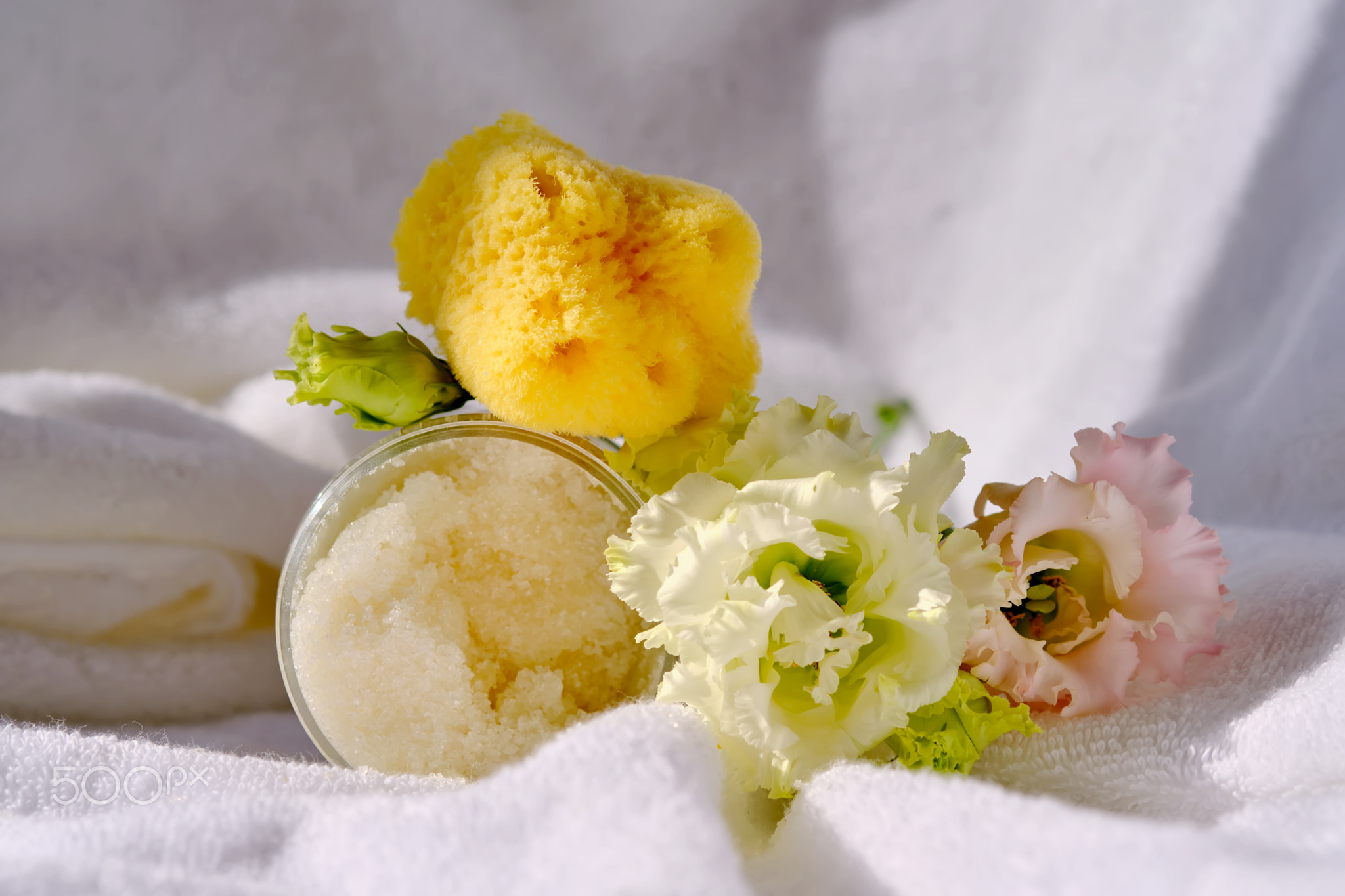 Scrub, loofah washcloth and organic sea sponge on the towel.