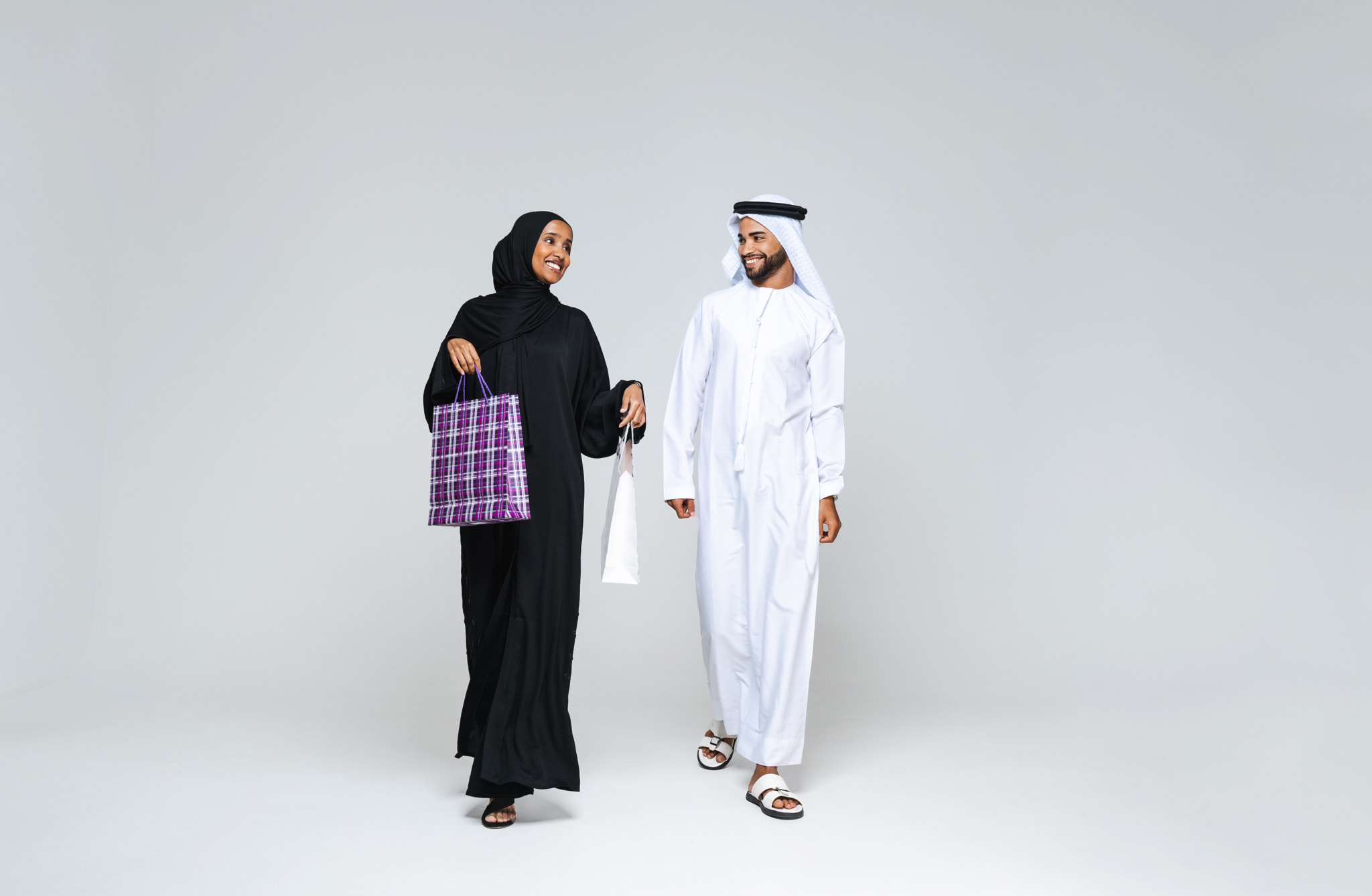 Beautiful arab middle-eastern couple with traditional emirate clothes in studio