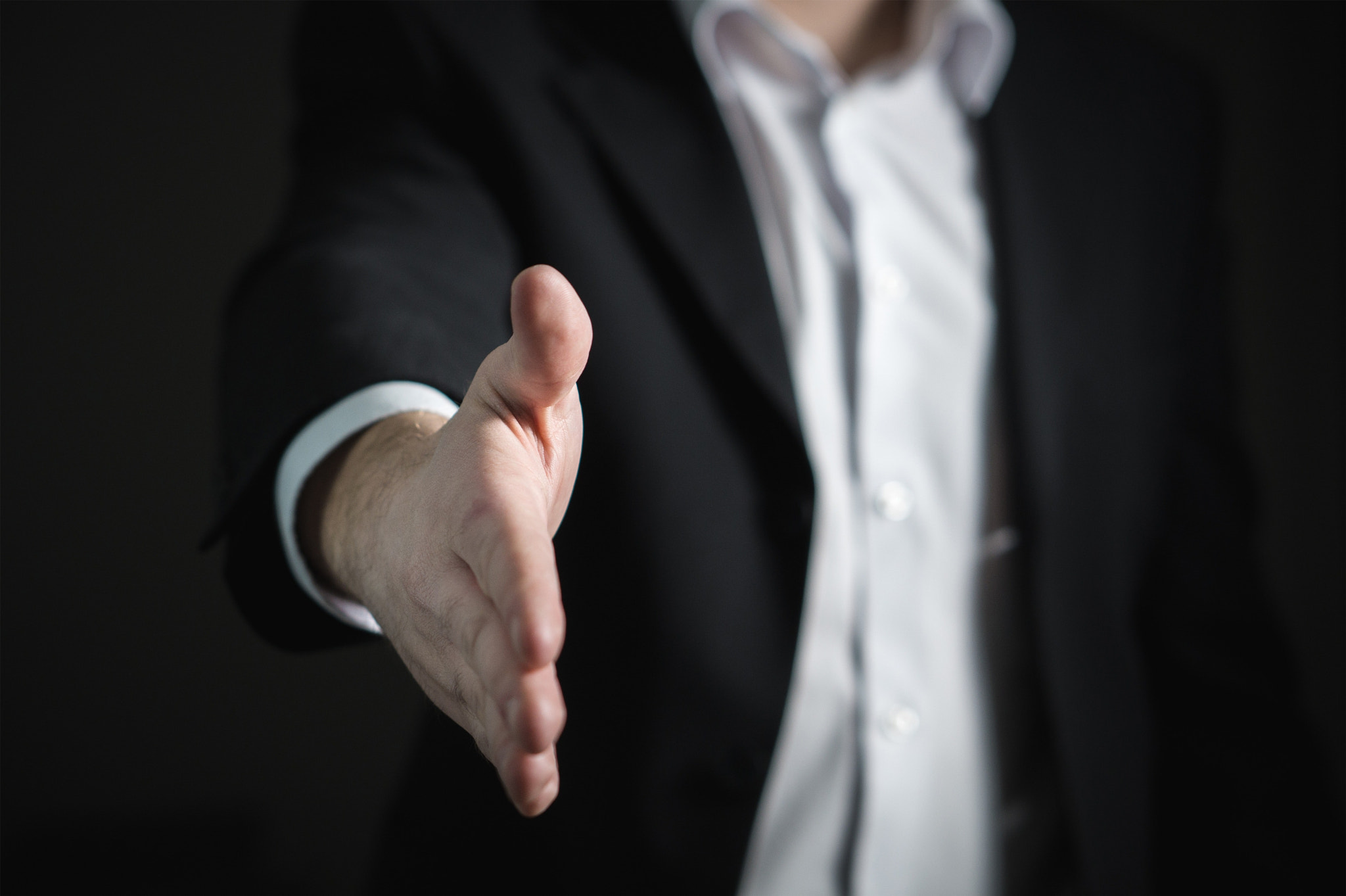 Midsection of businessman gesturing against black background