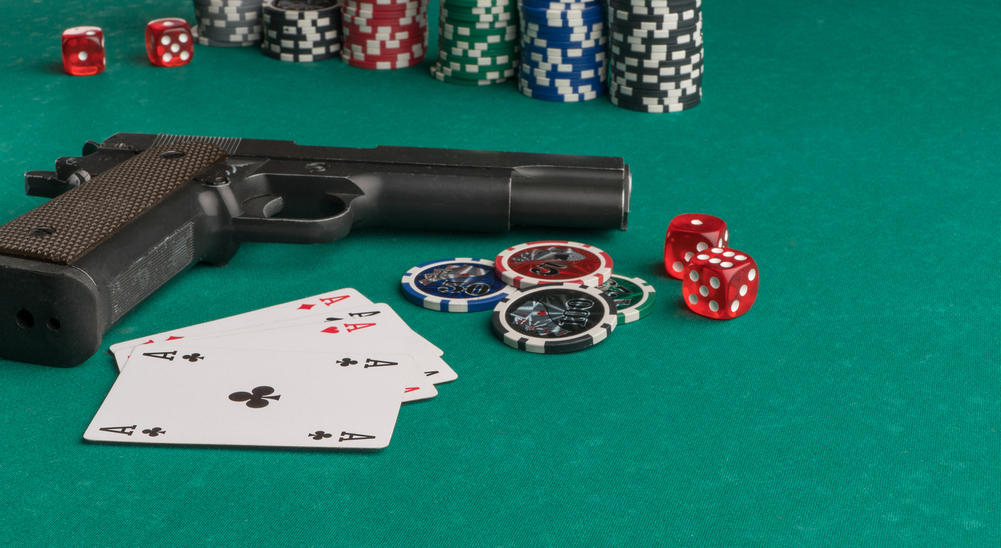 Poker chips, cards and gun on a green background. The concept of gambling and entertainment. Casino 