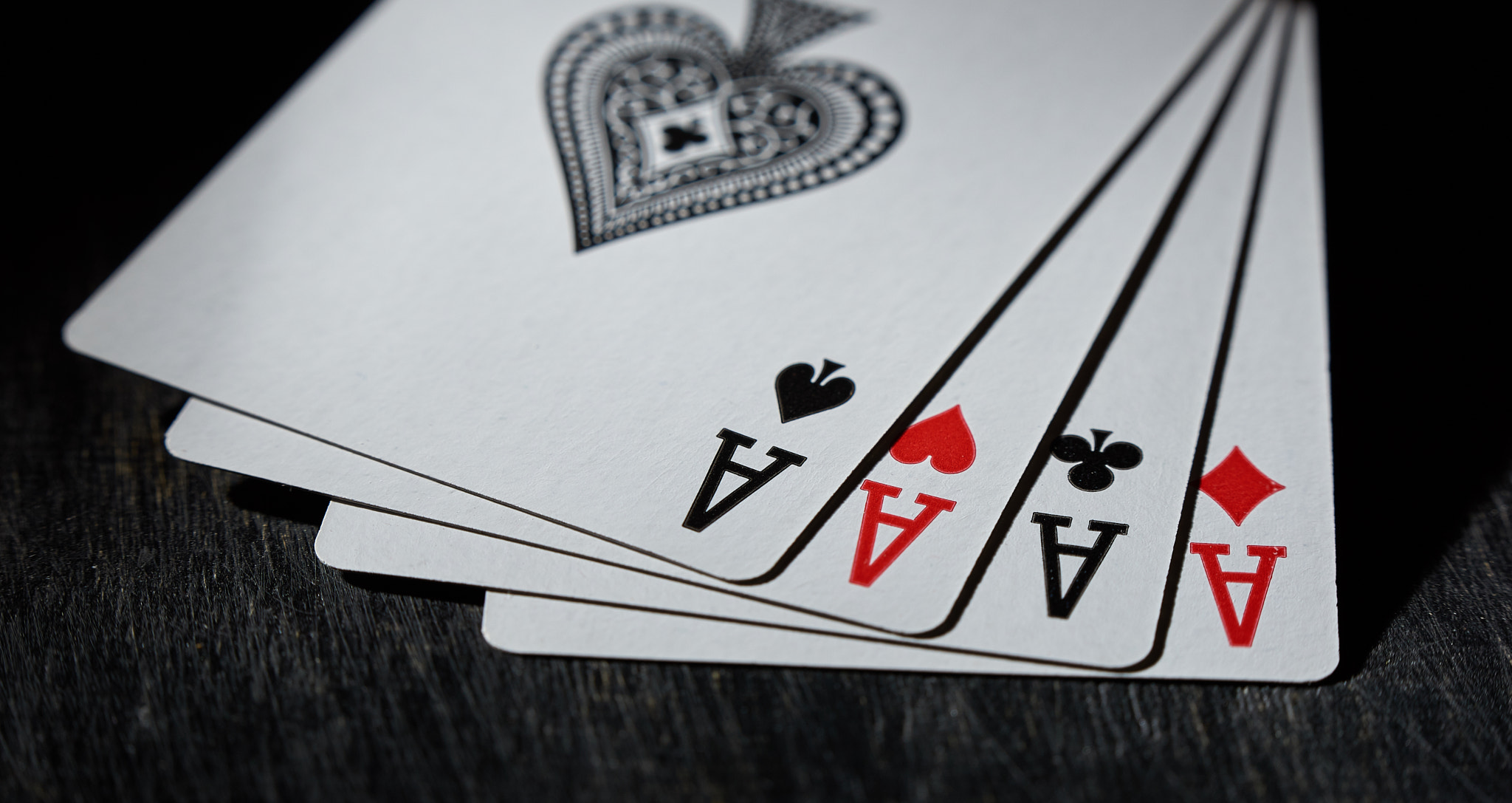 Playing card. Four aces close-up on a black background.