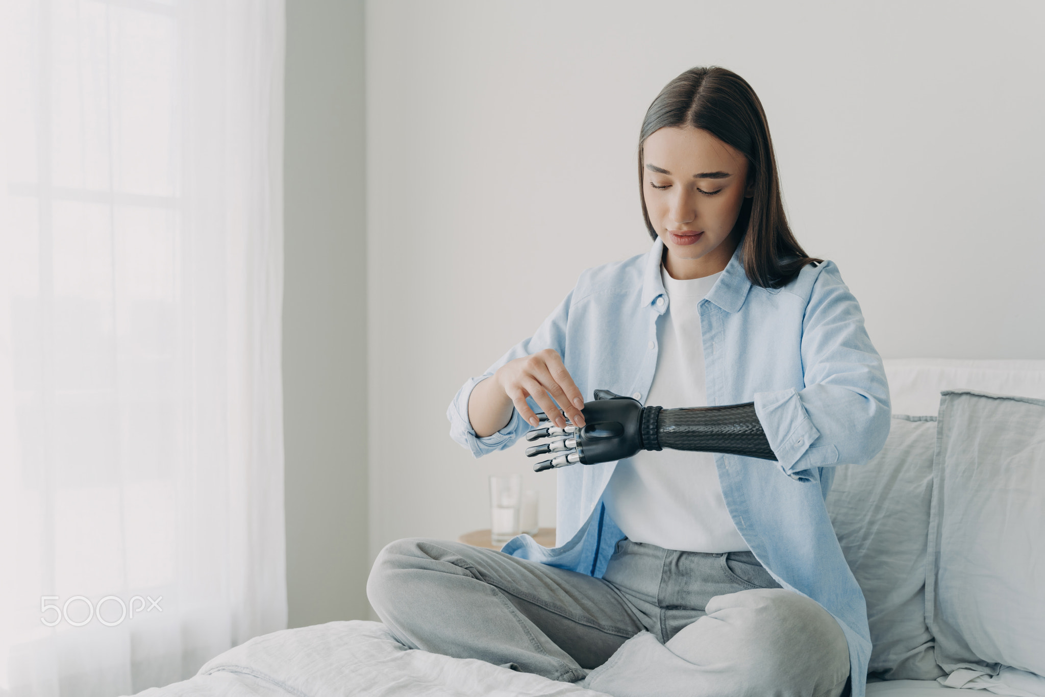 Handicapped young woman setting nerve control prosthesis parameters. Bionic artificial arm.
