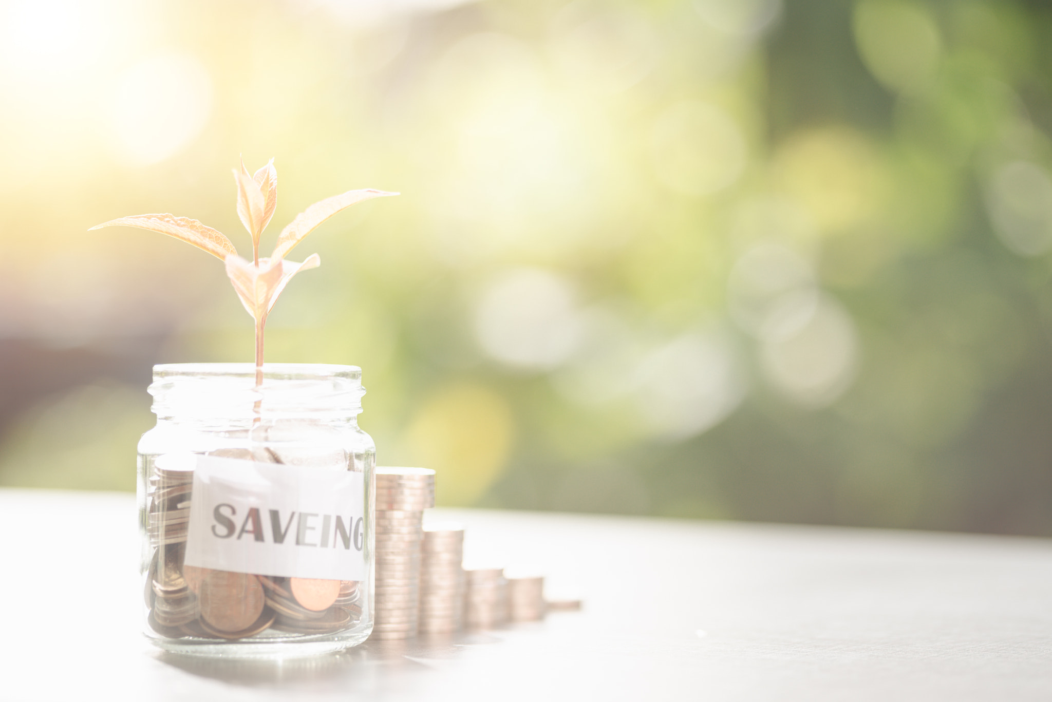 Message in a piece of paper and coins in a glass jar, stacked coins, savings ideas, financial growth